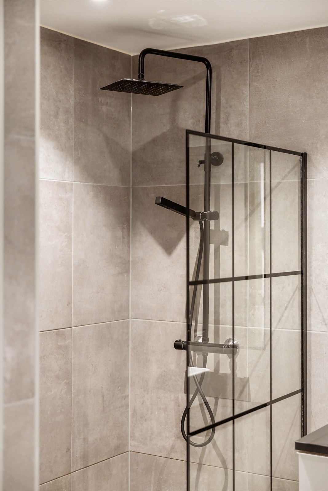 Dusjhjørnet har moderne dusjvegger og en regnfallsdusj. Galleribilde