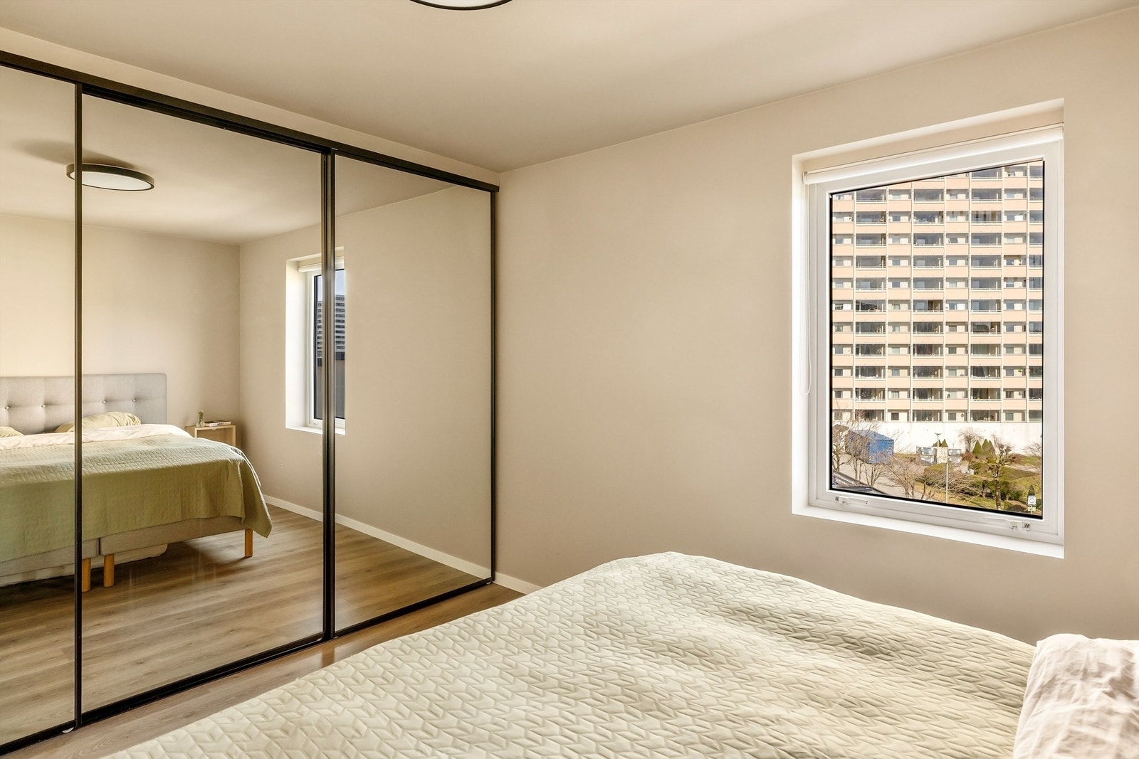 En stor skyvedørsgarderobe med speilfronter gir rikelig med oppbevaringsplass. Galleribilde