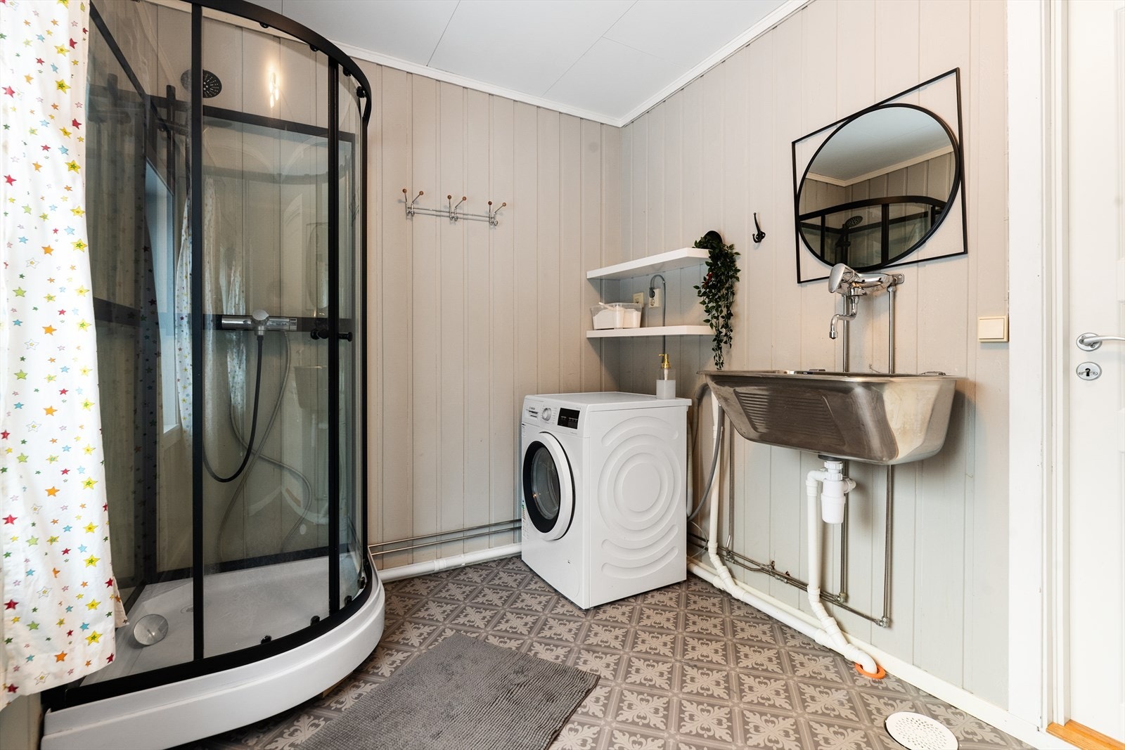 Kombinert bad- og vaskerom i underetasjen, med varmekabler, utslagsvask og opplegg for vaskemaskin. Nyere dusjkabinett. Galleribilde