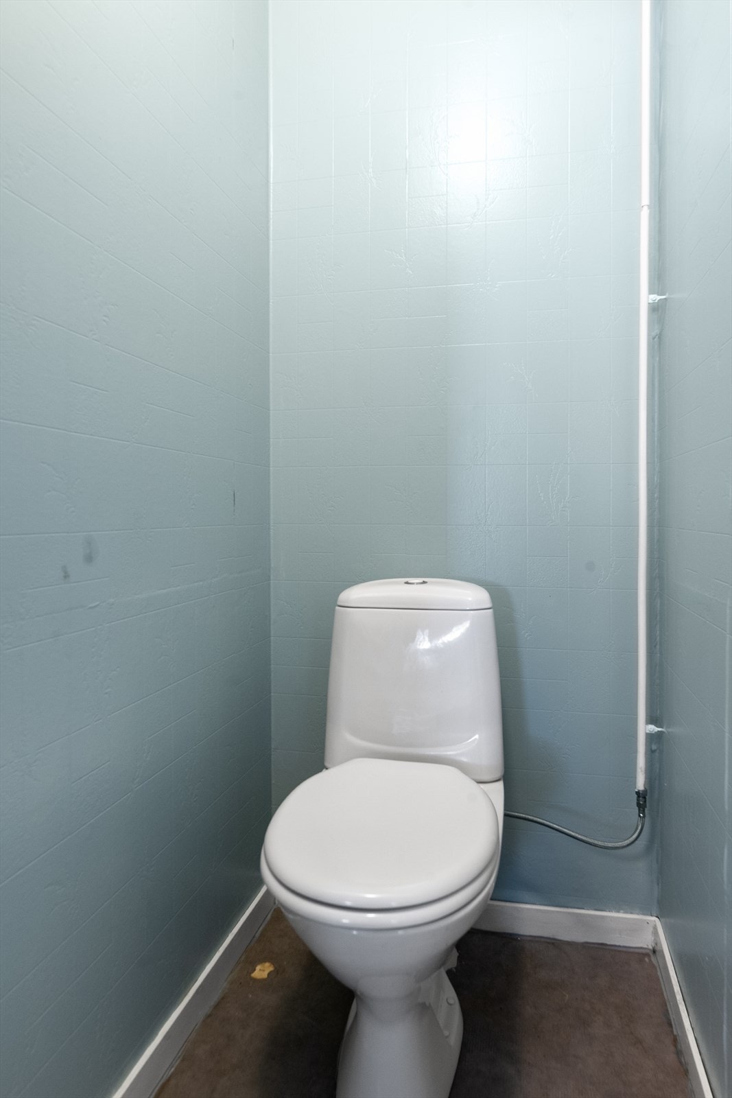 Lite toalettrom i underetasjen, med gulvmontert toalett. Galleribilde