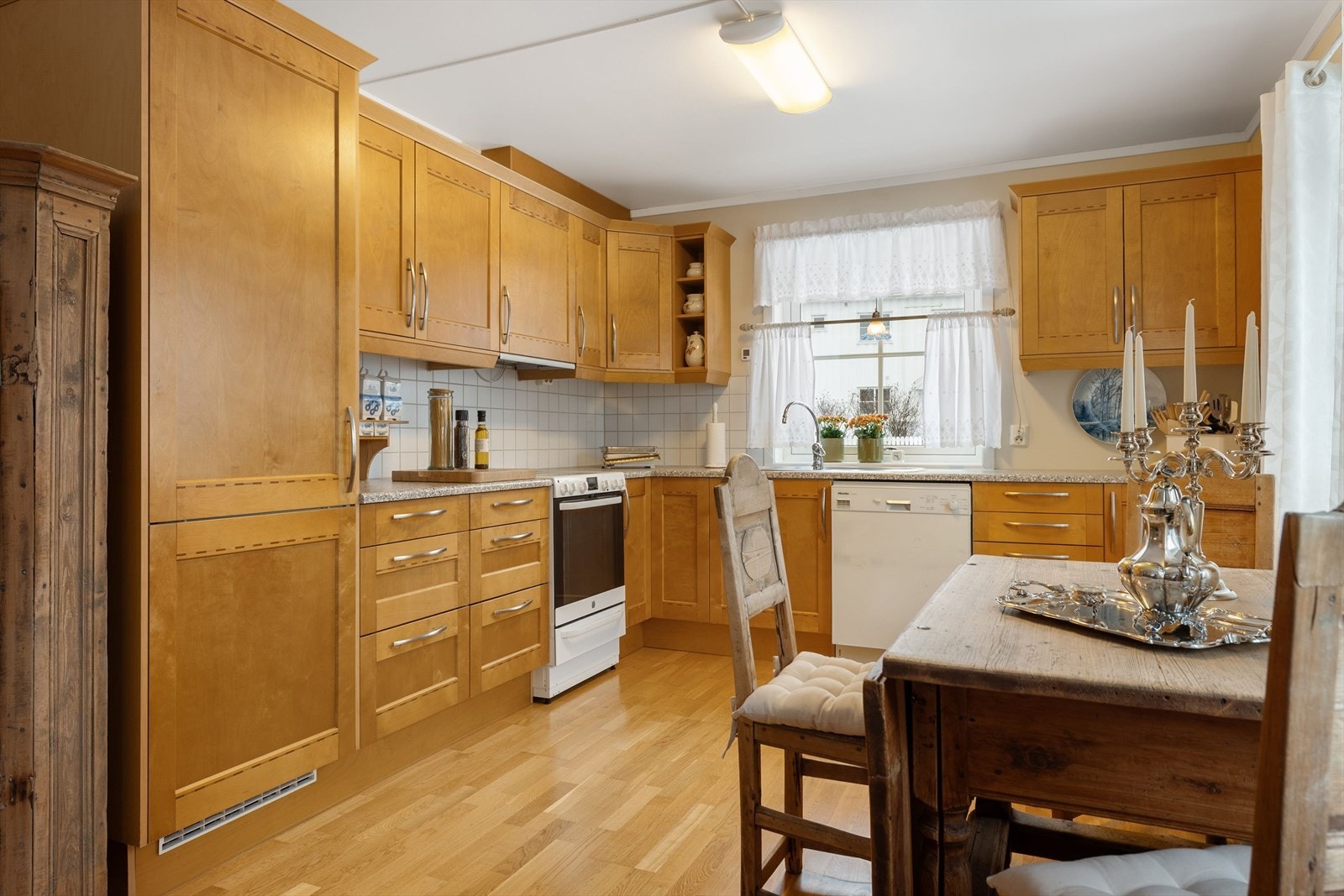 Kjøkkeninnredning med profilerte fronter og benkeplate av laminat. Det er integrert kjøl-/fryseskap. Galleribilde