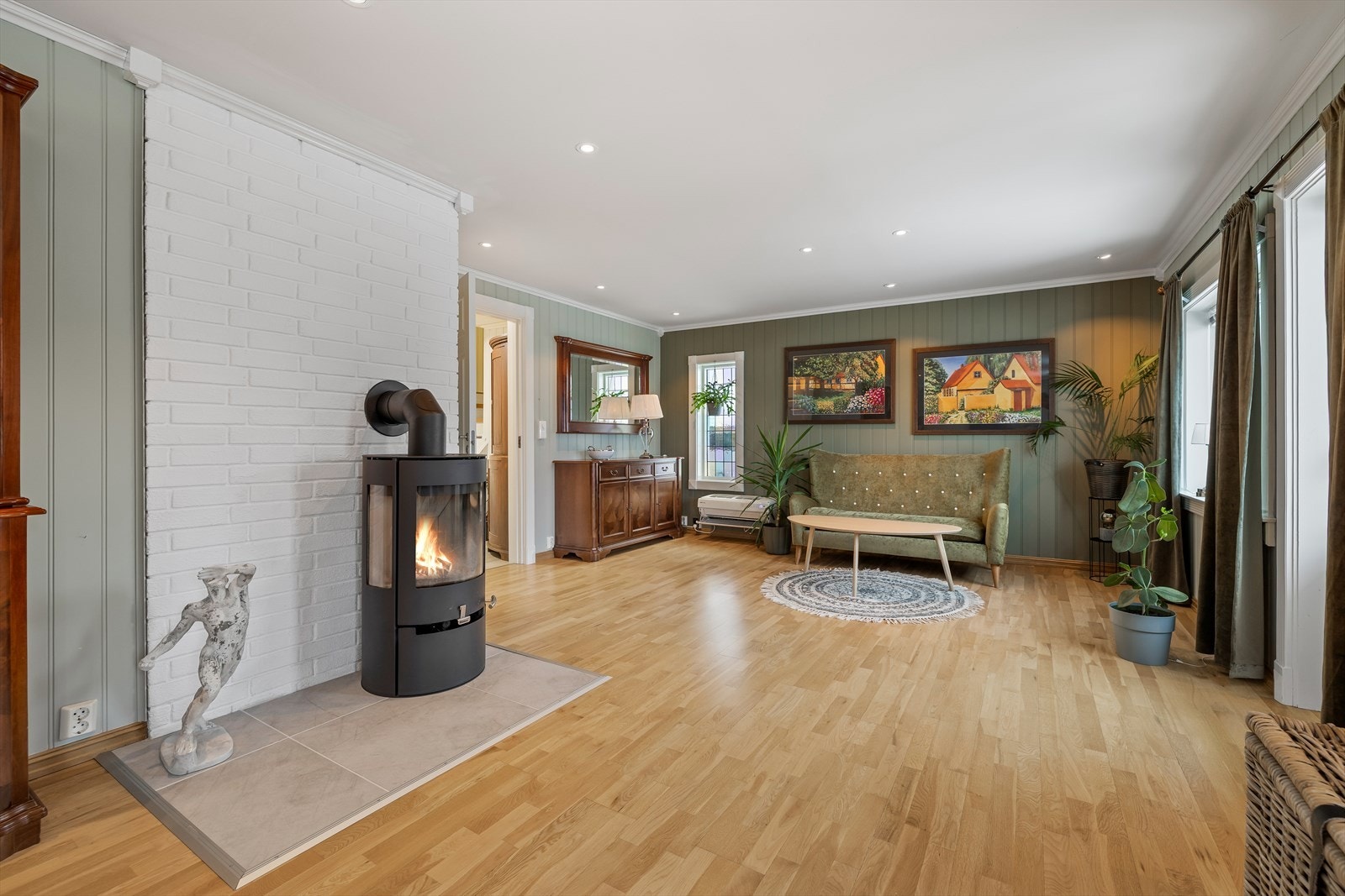 Romslig stue som er hjerte av boligen, det er 3-stavs parkett på gulv og malte MDF plater på vegger Galleribilde