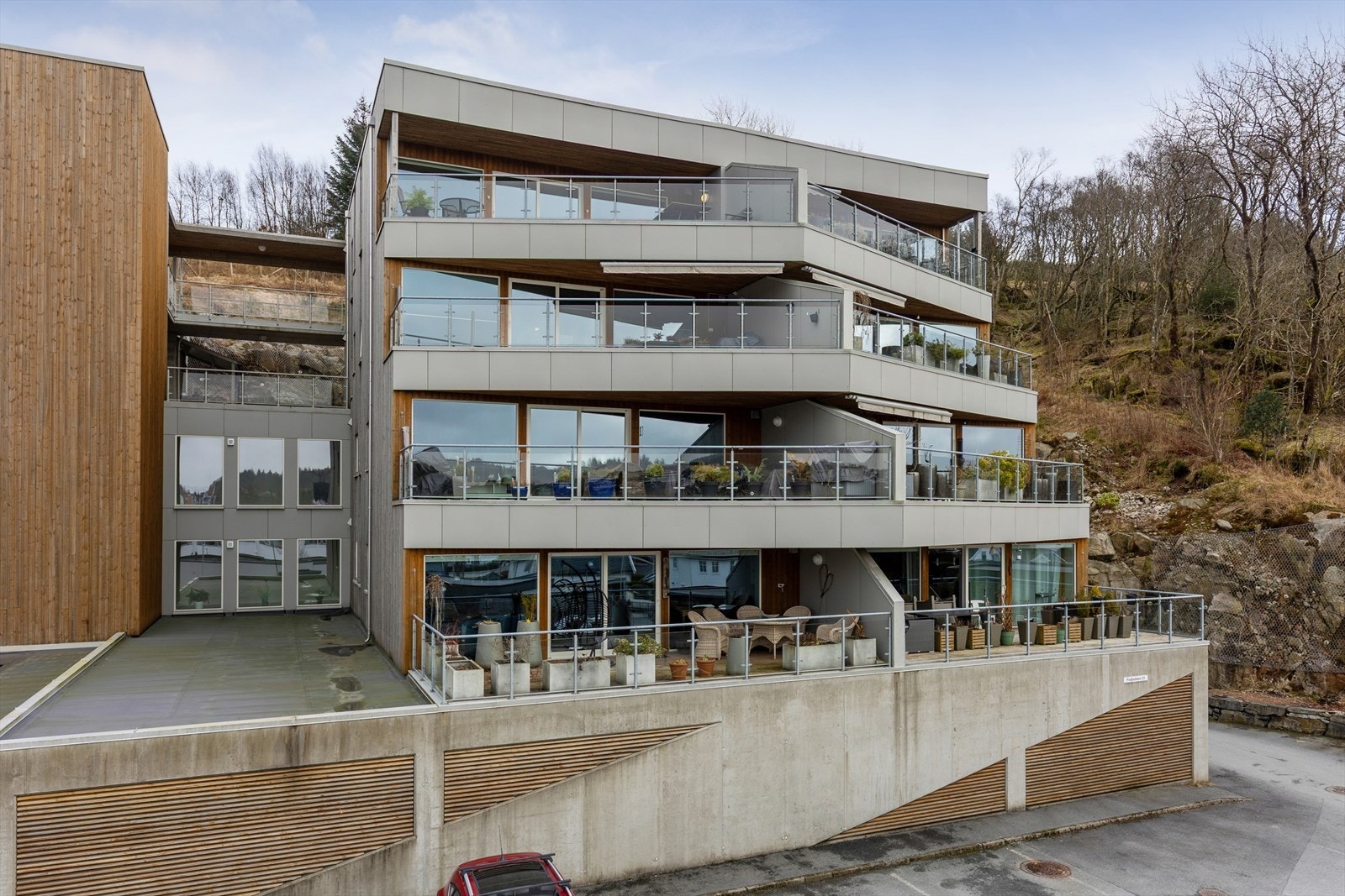 Bygget fremstår som et moderne samspill mellom tre, betong og store glassflater - en stilren arkitektur som glir naturlig inn i terrenget. Galleribilde