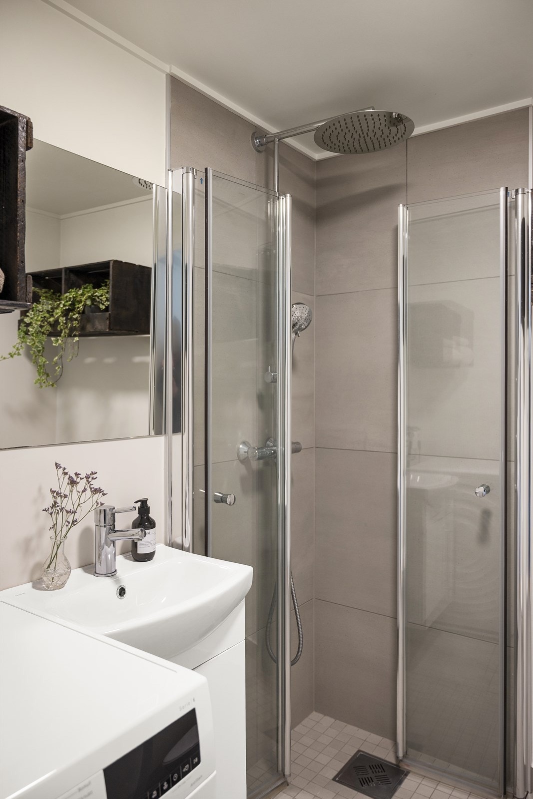 Badet ble ombygd i 2020 med ny membran og fliser. Rommet er delikat og funksjonelt, utstyrt med toalett, servant med innredning, dusjhjørne og opplegg for vaskemaskin, samt stilige vegghengte kasser. Galleribilde