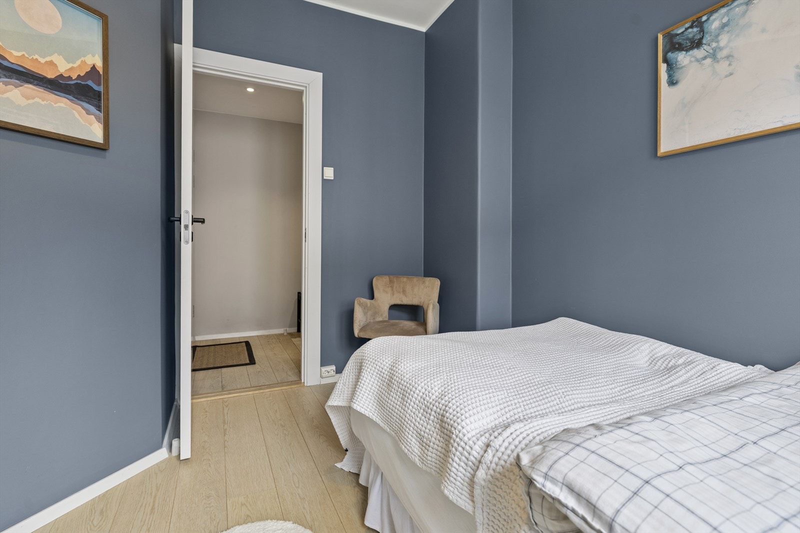 Soverommet har en behagelig blåfarge på veggene og gjennomgående parkett som resten av boligen, noe som gir et helhetlig og harmonisk uttrykk. Galleribilde