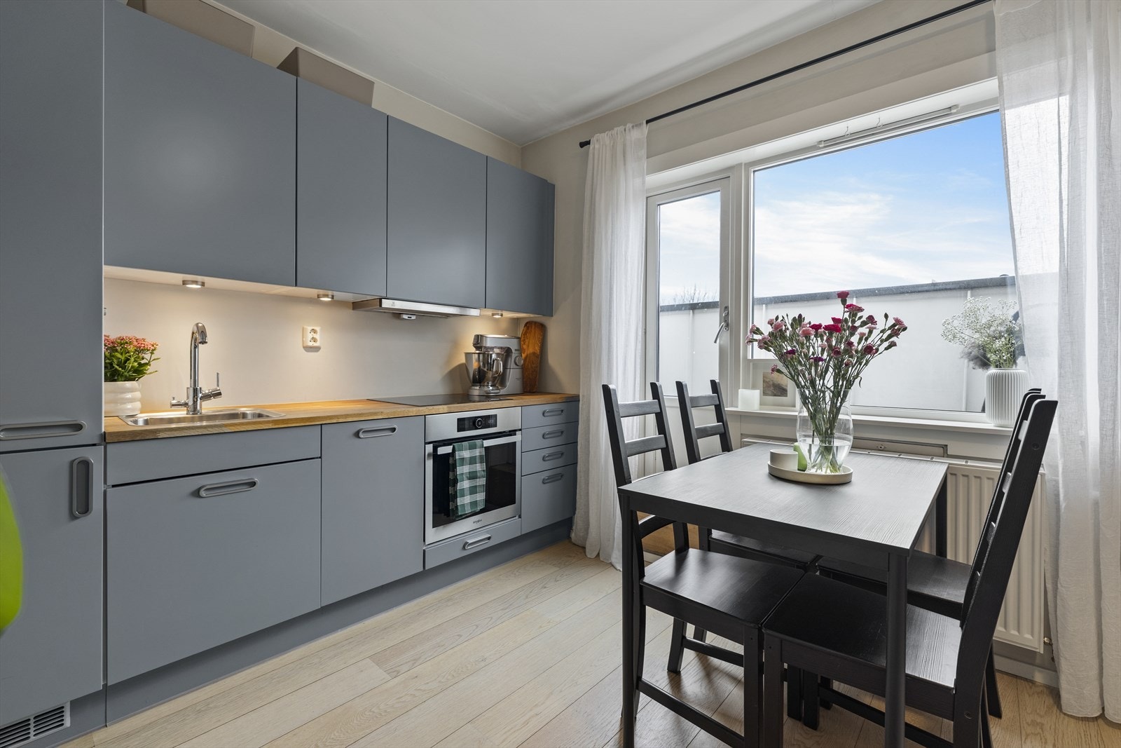 Stilrent og moderne kjøkken fra HTH med integrerte hvitevarer og induksjonstopp. Her er det direkte utgang til balkong. Galleribilde