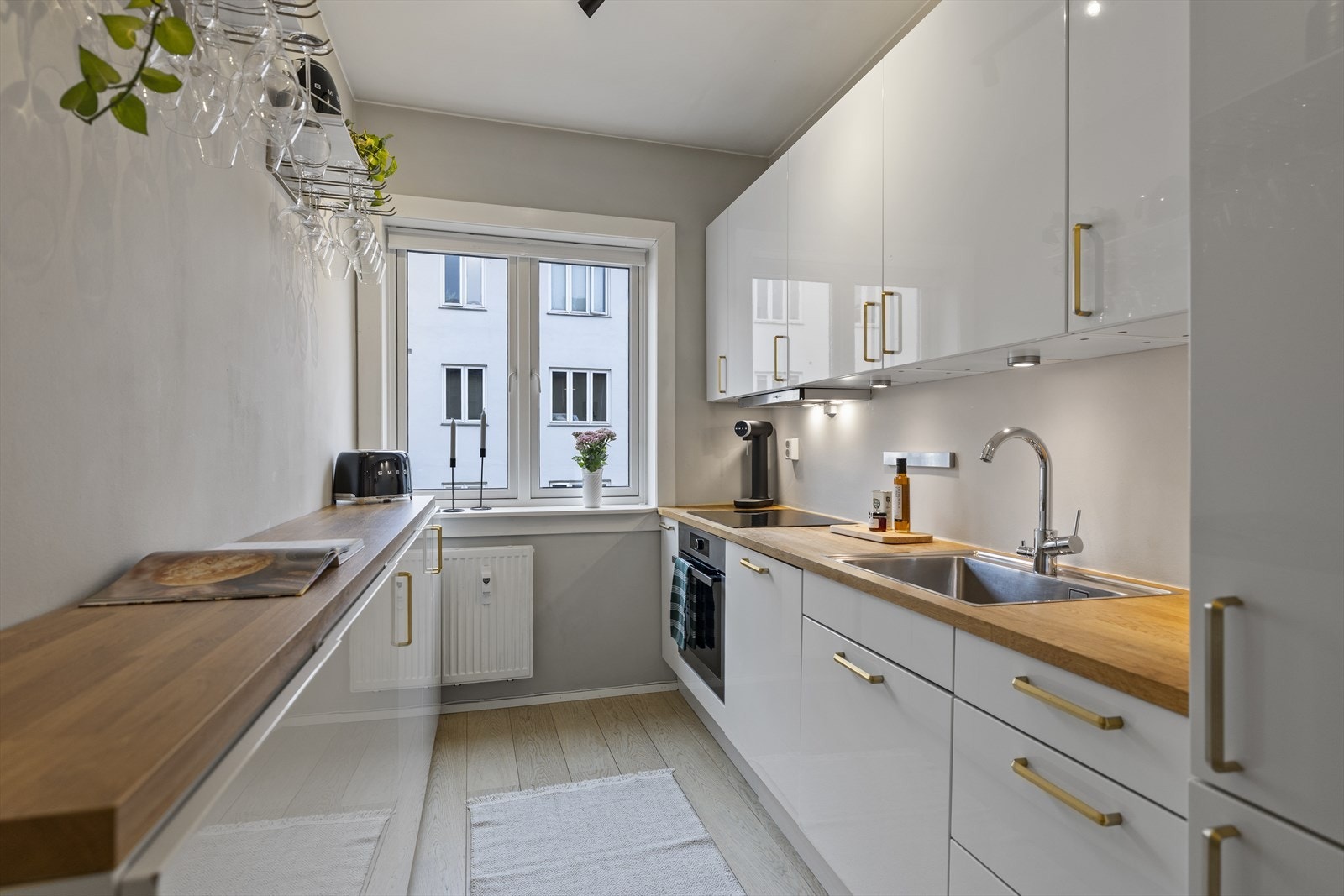 Stilrent kjøkken fra HTH (2017), utstyrt med integrerte hvitevarer og induksjonstopp. Galleribilde