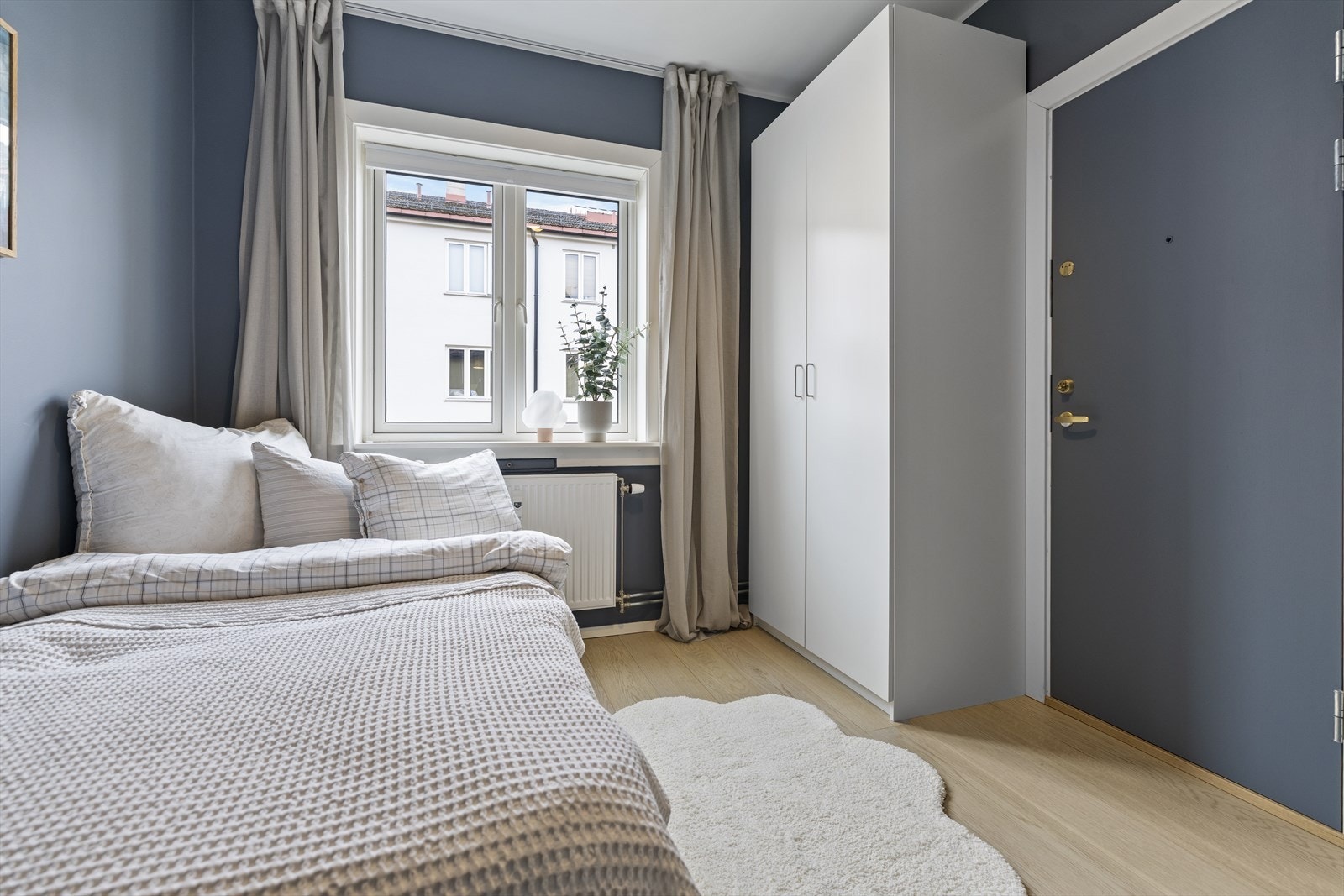 Soverom 2 kan innredes etter eget ønske, og skapet på bildet medfølger boligen. Vinduet vender ut mot en rolig bakgård, som gir en stille og skjermet atmosfære. Rømningsvei ut mot baktrappen fra soverommet. Galleribilde