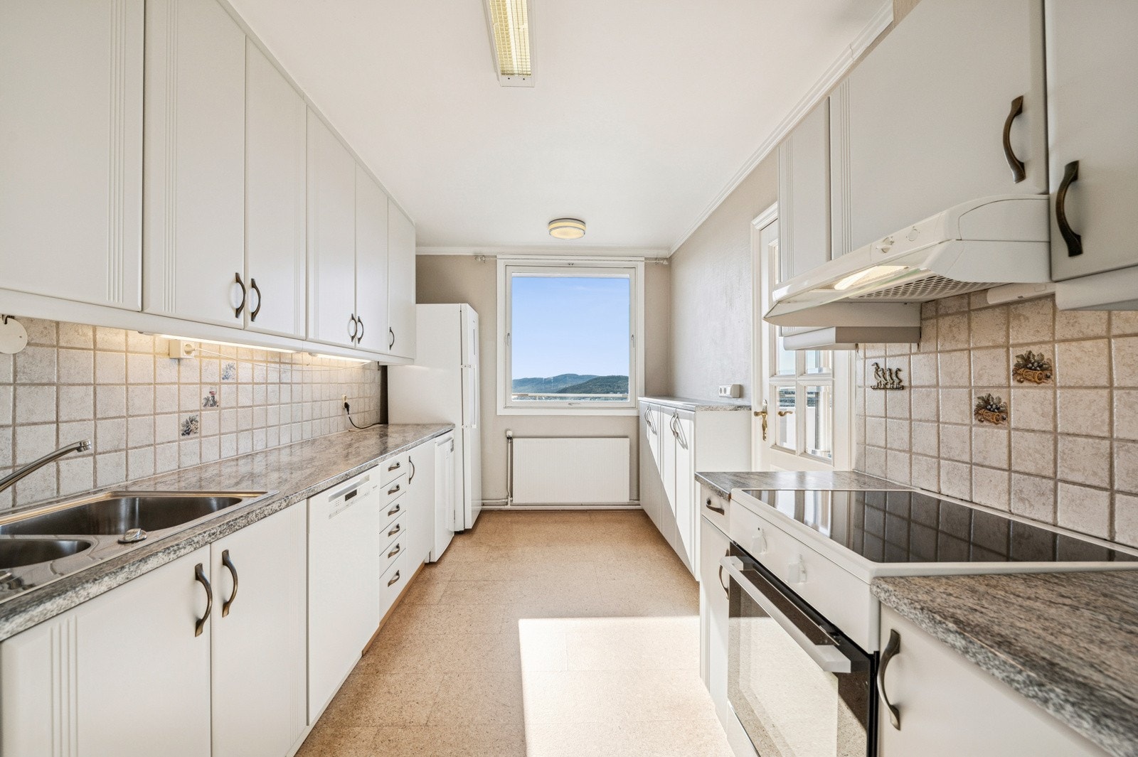 Lyst kjøkken med mye skapplass og fin utsikt. Galleribilde