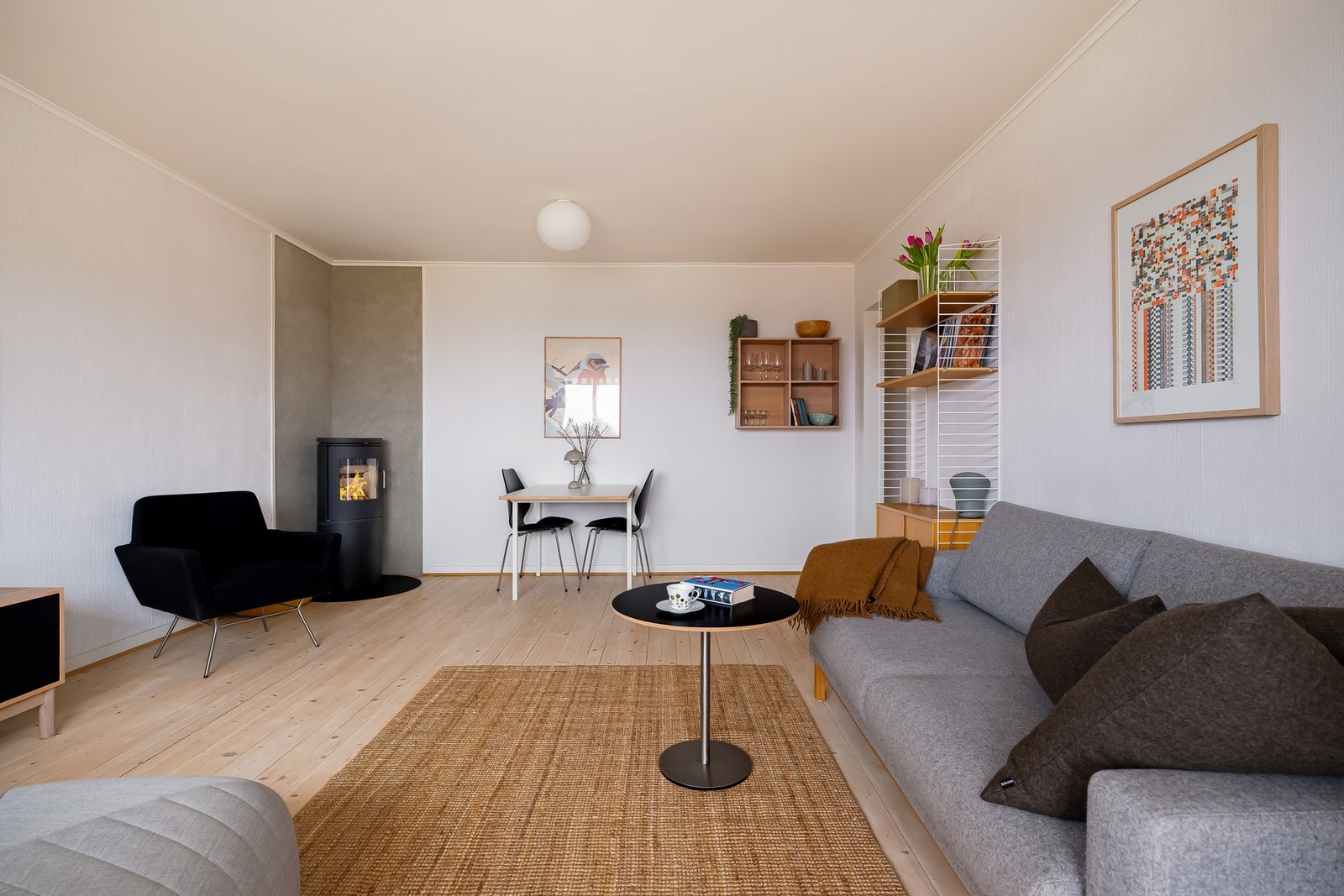 I hjørnet av rommet er det plassert en moderne peisovn. Galleribilde