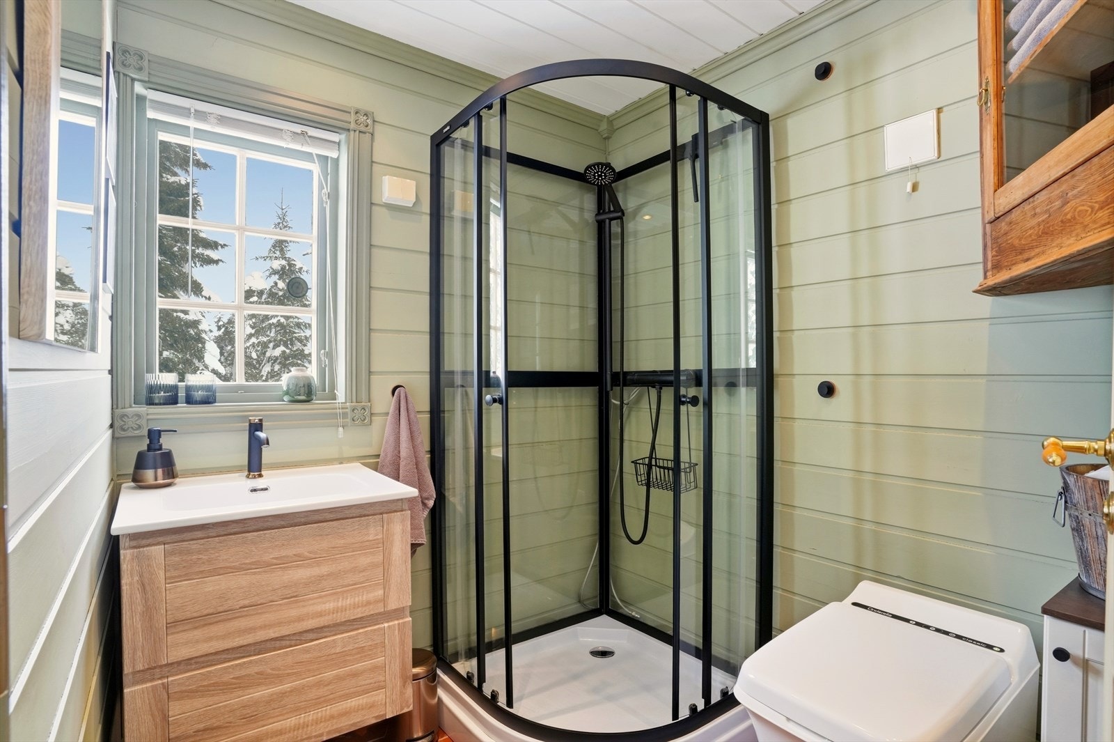 Rom innredet med servant i innredning, dusjkabinett og Cinderella forbrenningstoalett. Galleribilde