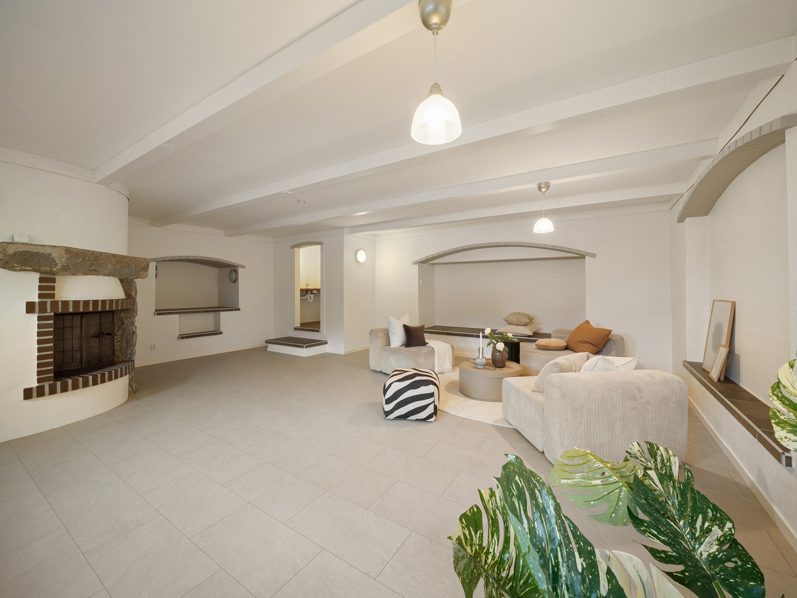 Kjellerstuen har vannbåren varme i gulv og åpen gruvepeis. I enden av kjellerstuen er det et lite rommet med enkel vask. Galleribilde