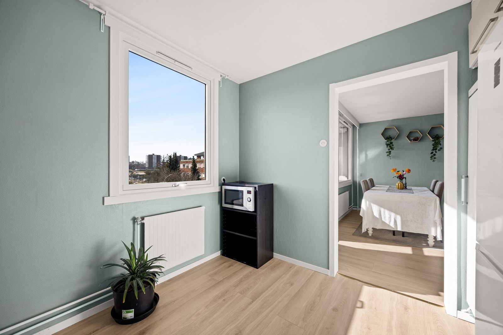 Lyst kjøkken med vindu som slipper inn godt med dagslys og gir en åpen romfølelse mot spiseplass. Galleribilde