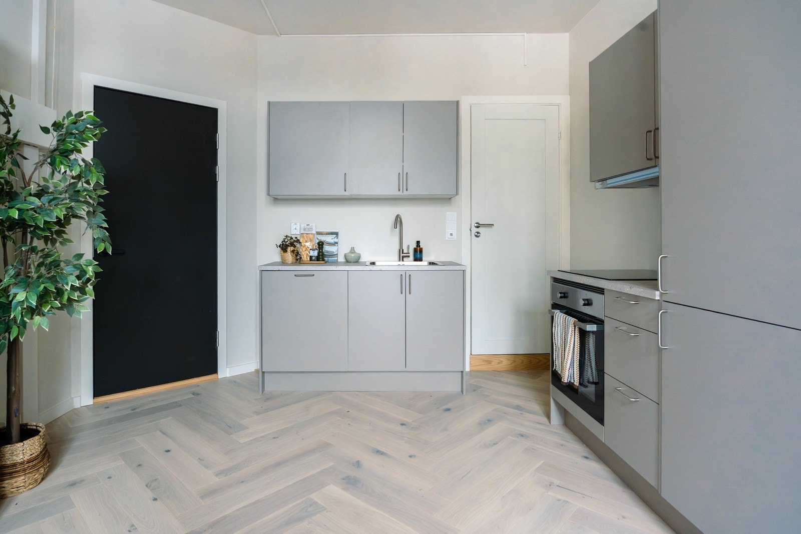 Praktisk utformet kjøkken utført i glatte fronter med moderne fargevalg Galleribilde