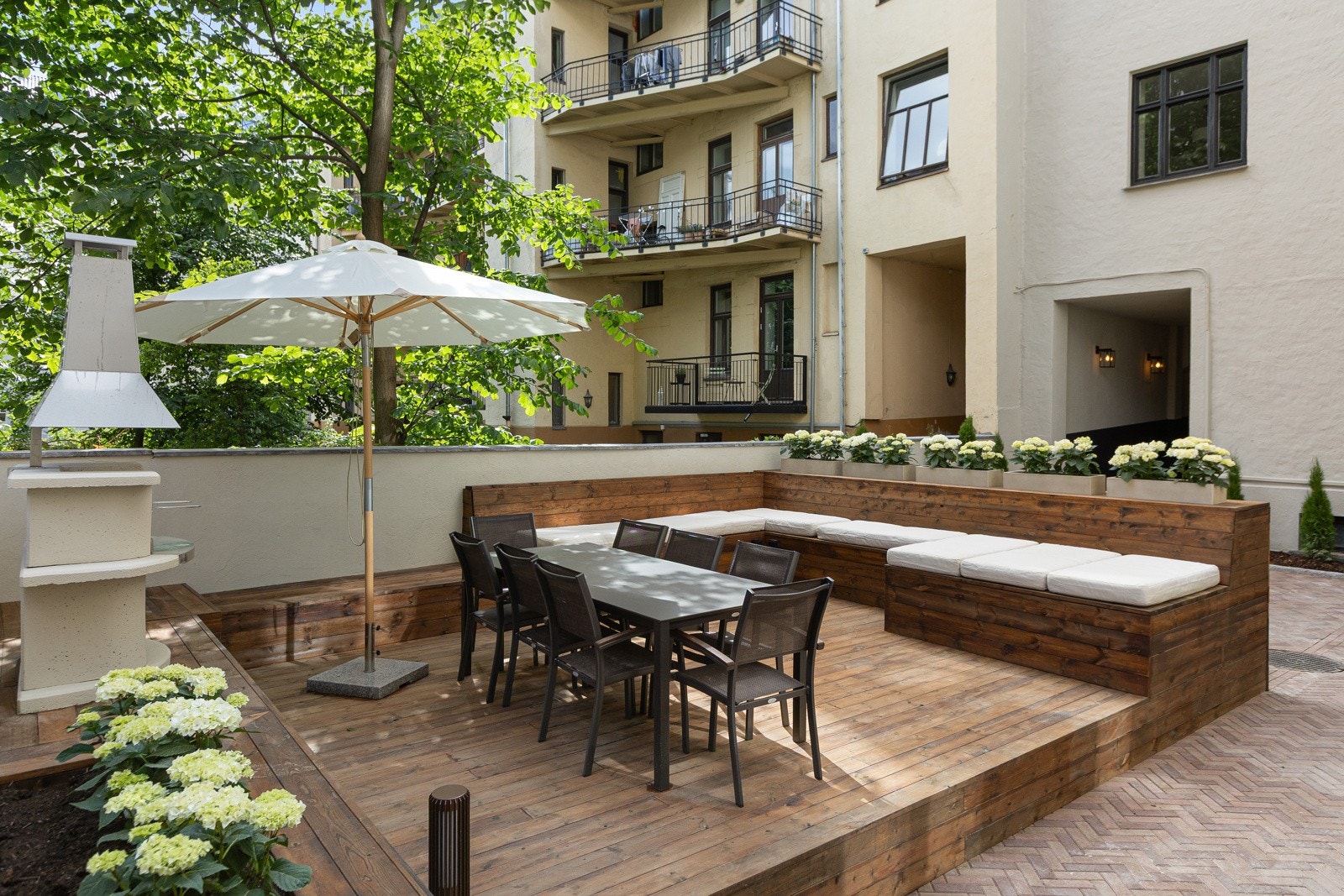 Hovedbakgården byr også på frodig beplantning, pizzaovn og strømuttak ved sittebenkene - perfekt dersom en vil trekke ut på solfylte sommerdager Galleribilde