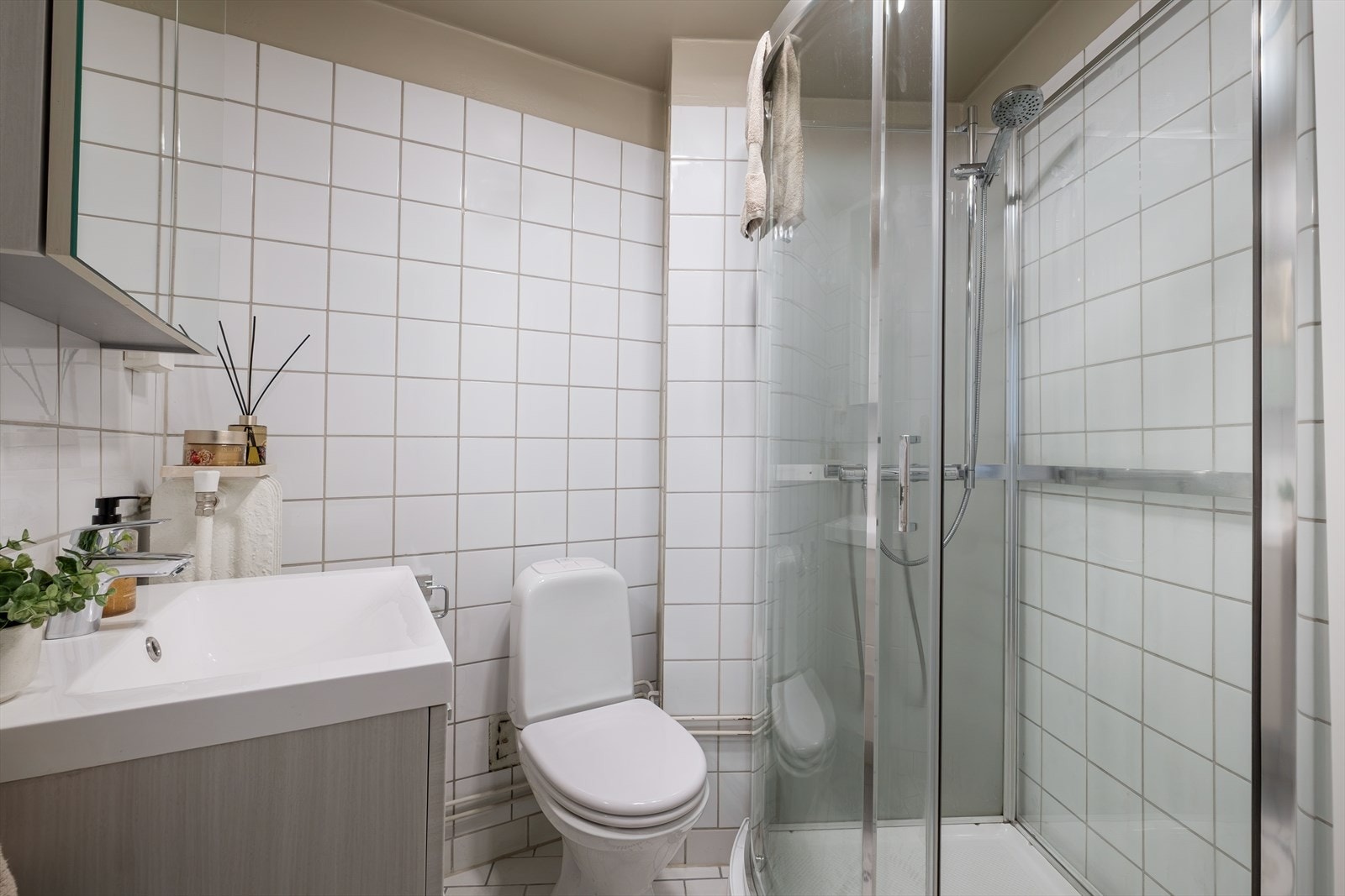 Lyst og pent flislagt bad, hvor baderomsinnredningen ble byttet i 2021 av tidligere eier Galleribilde