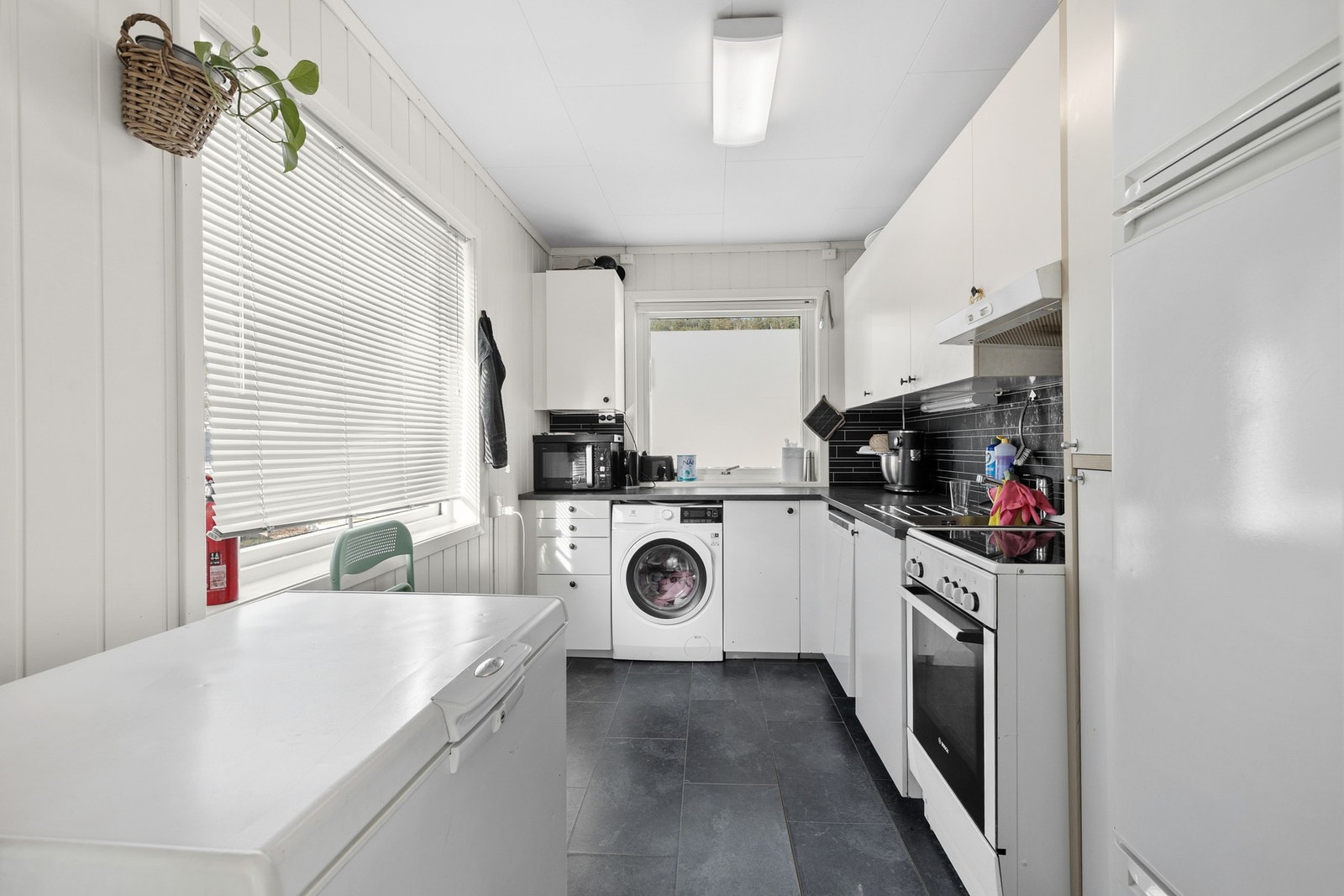 Kjøkkenet har innredning med slette fronter og benkeplate med laminert overflate Galleribilde