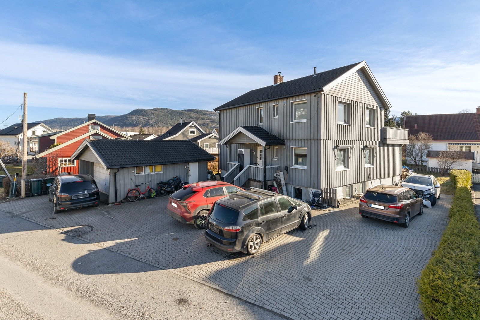 Gode parkeringsmuligheter i frittstående garasje og hellelagt gårdsplass Galleribilde