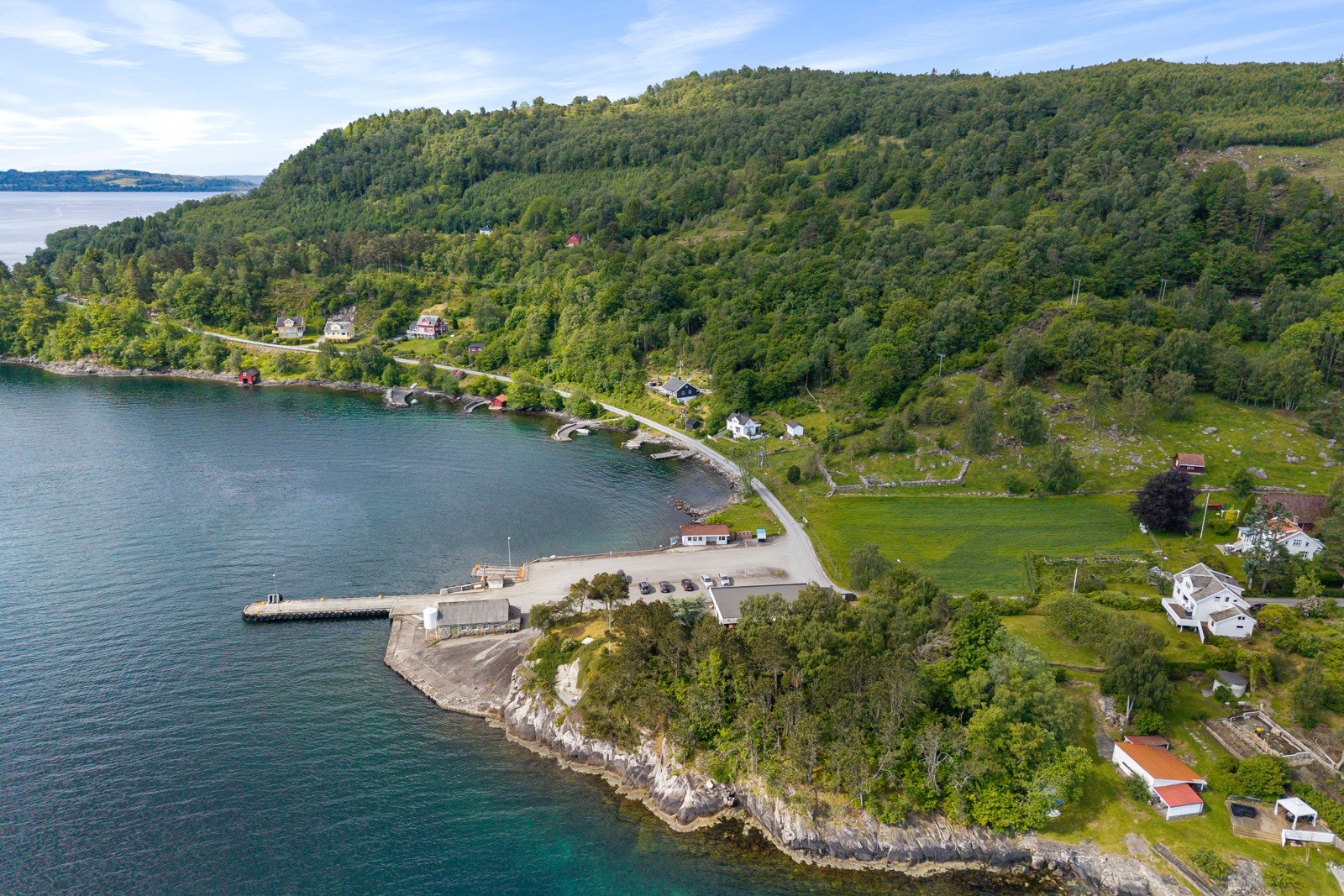Tomten strekker seg også innover i et skogkledd område med blandingsskog. Skogspartiet gir skjerming mot innsyn, og tilfører eiendommen et naturpreget og tilbaketrukket preg. Galleribilde