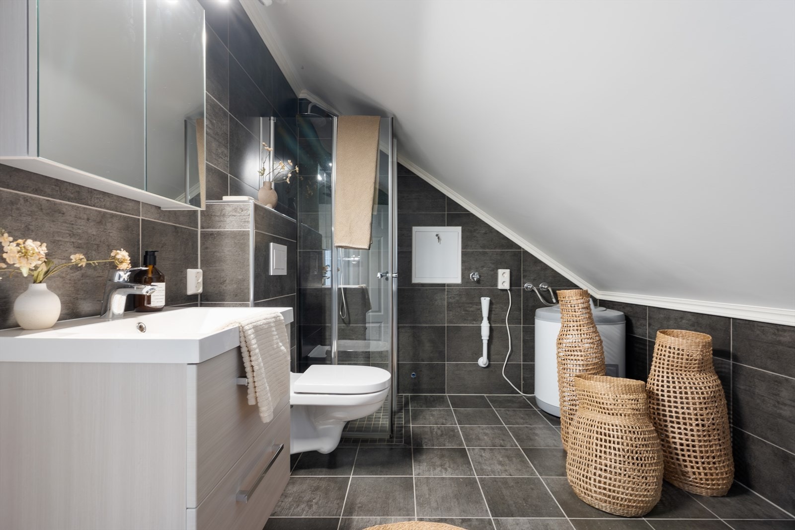 Flott bad som er utstyrt med dusjhjørne, servantmøbler og vegghengt toalett. Merk at det en egen varmtvannsbereder, dersom utleie. Galleribilde