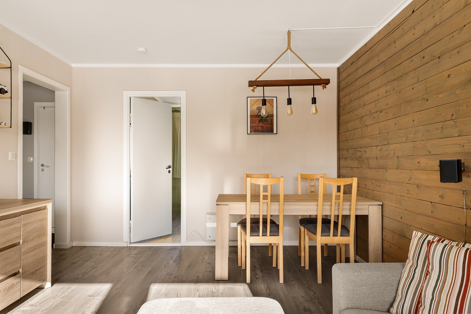 Stuen har en egen sone for spiseplass, rammet inn av en vegg med trepanel som gir varme til rommet. Galleribilde