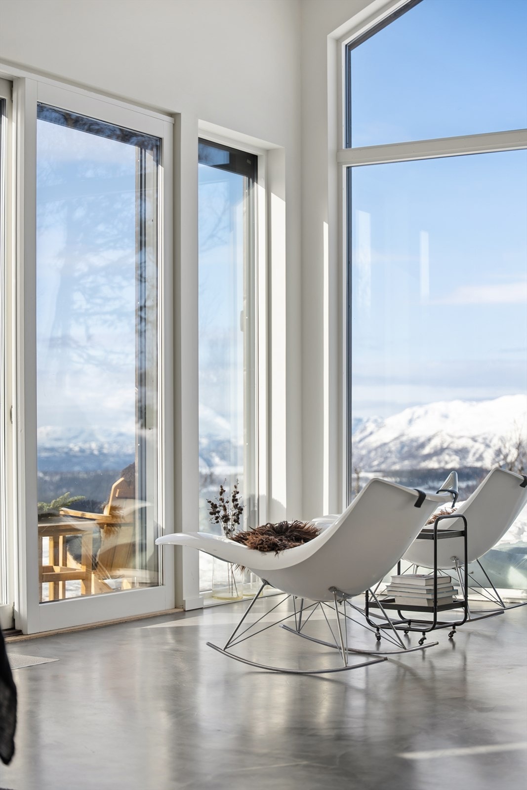 De store vindusflatene i denne delen av rommet utnytter utsikten over fjellandskapet på en særdeles god måte og gir en spektakulær ramme rundt oppholdsrommet Galleribilde