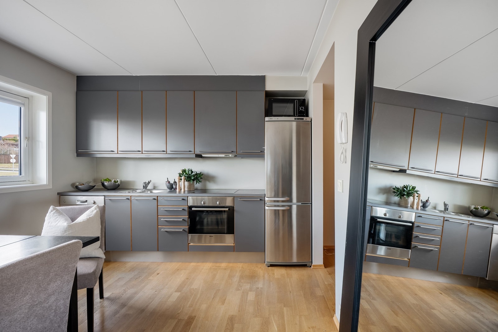 Kjøkkenet er i moderne og fint design med grå fronter og mørk benkeplate. Galleribilde