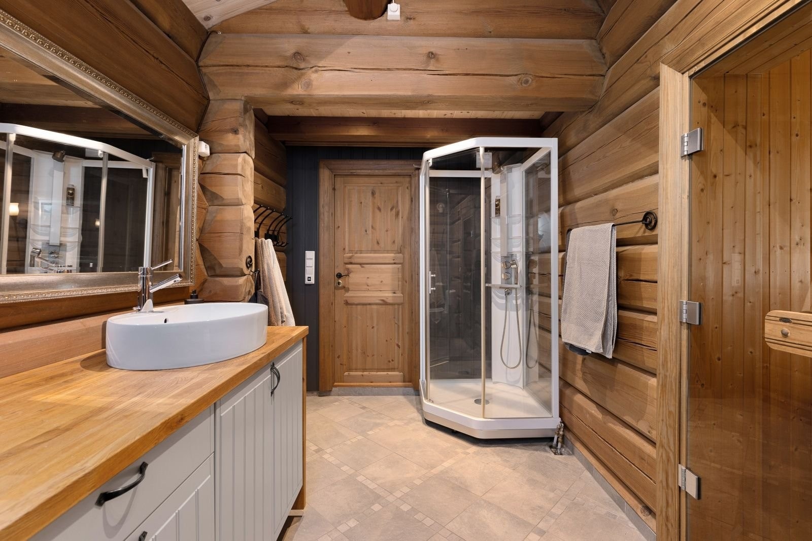 Badet i 1. etg. har dusjkabinett og skiferfliser med god varme i gulvet. Galleribilde