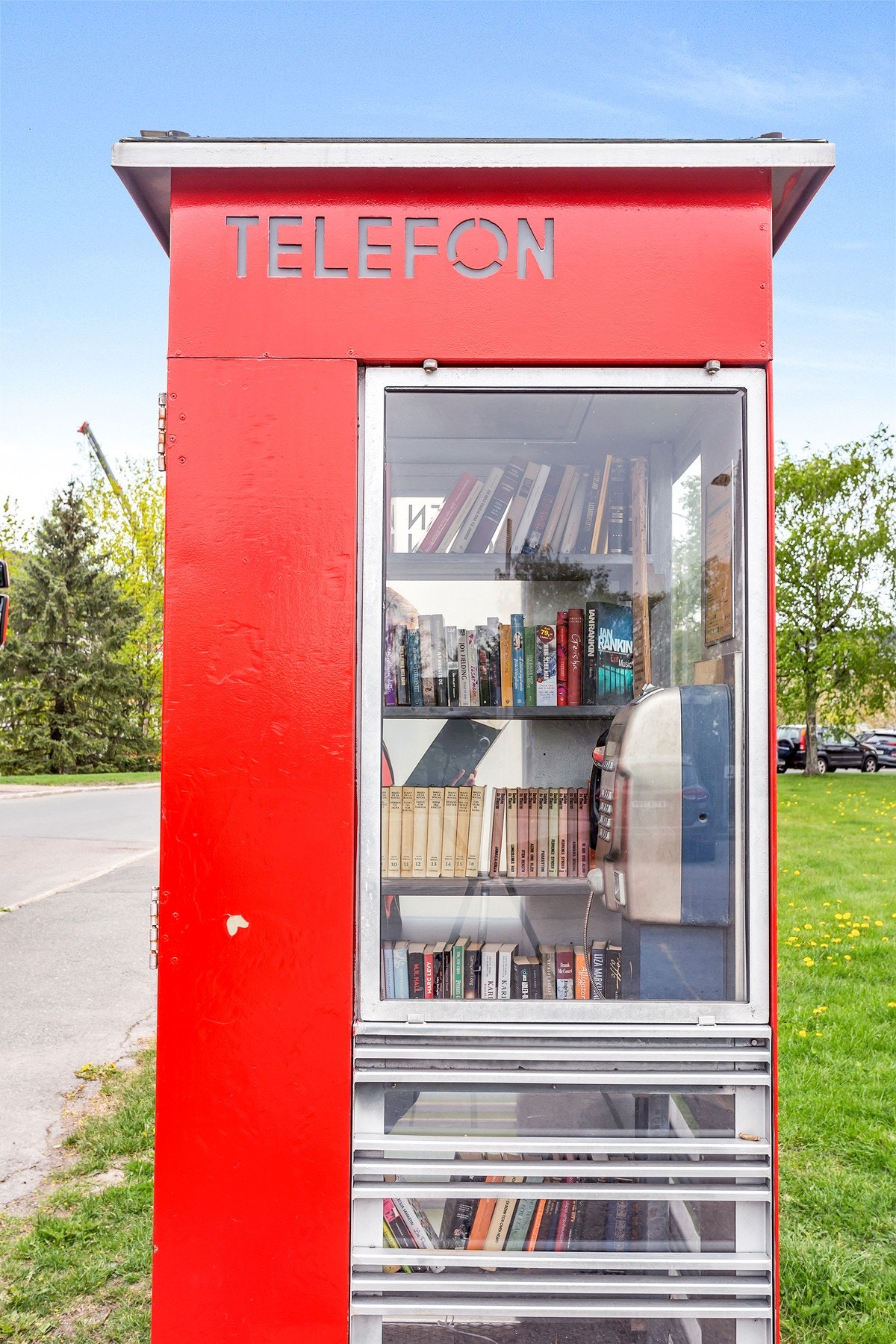 Ikonisk telefonkiosk med byttelån av bøker Galleribilde