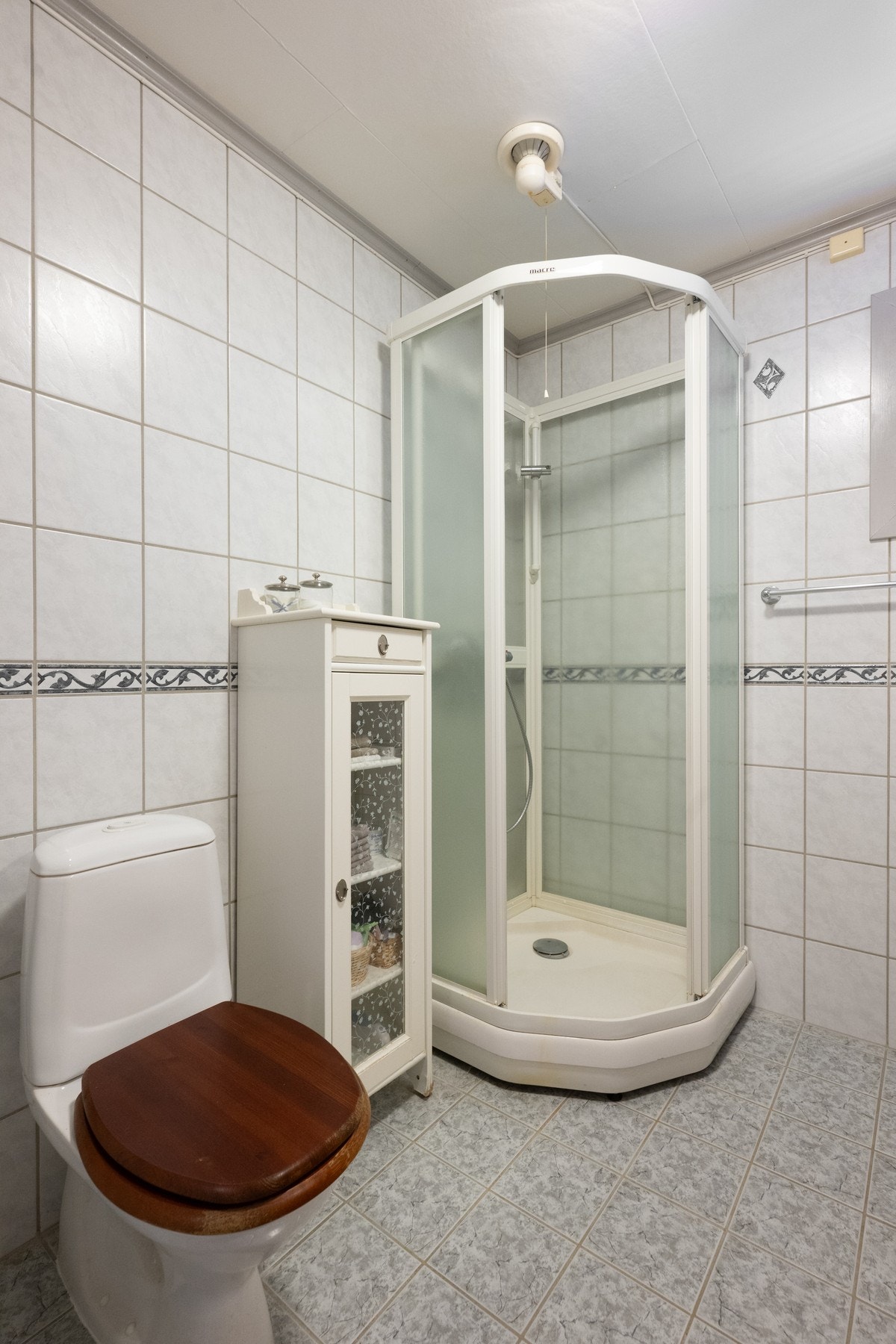 Badet er innredet med servant med underskap, dusjkabinett, WC og opplegg for vaskemaskin. Galleribilde