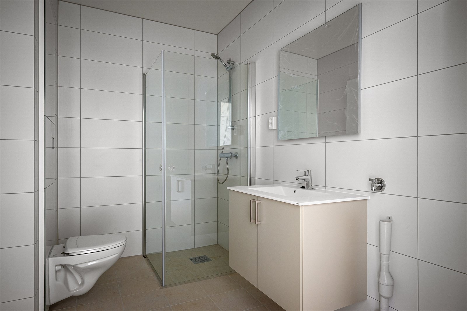 Pent helfliset bad med wc, dusjhjørne, vask i seksjon og varme i gulv for ekstra komfort. Galleribilde