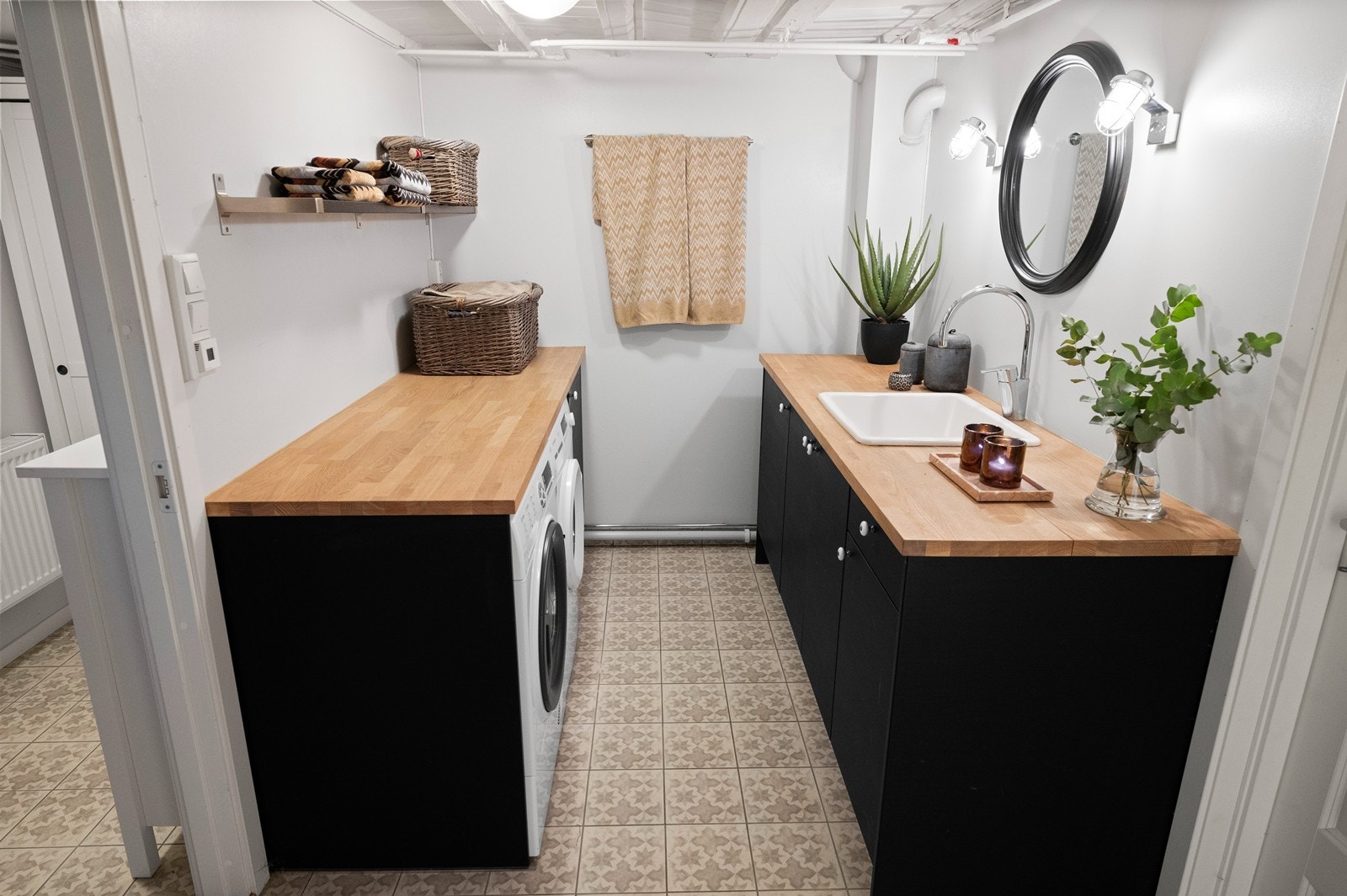 Det store og praktiske vaskerommet , oppgradert med nye overflater i 2017. På gulvet er det fliser og på veggene er det malte flater. Det er pen innredning med nisje for vaskemaskin og tørketrommel, i tillegg til innredning med nedfelt servant. Galleribilde