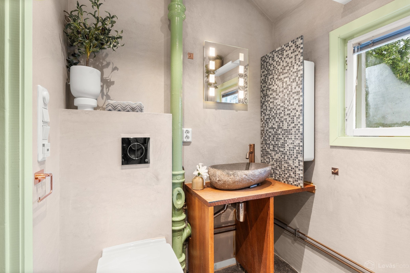 Rommet er utstyrt med vegghengt toalett og en stilren servantinnredning i massiv eik. Galleribilde