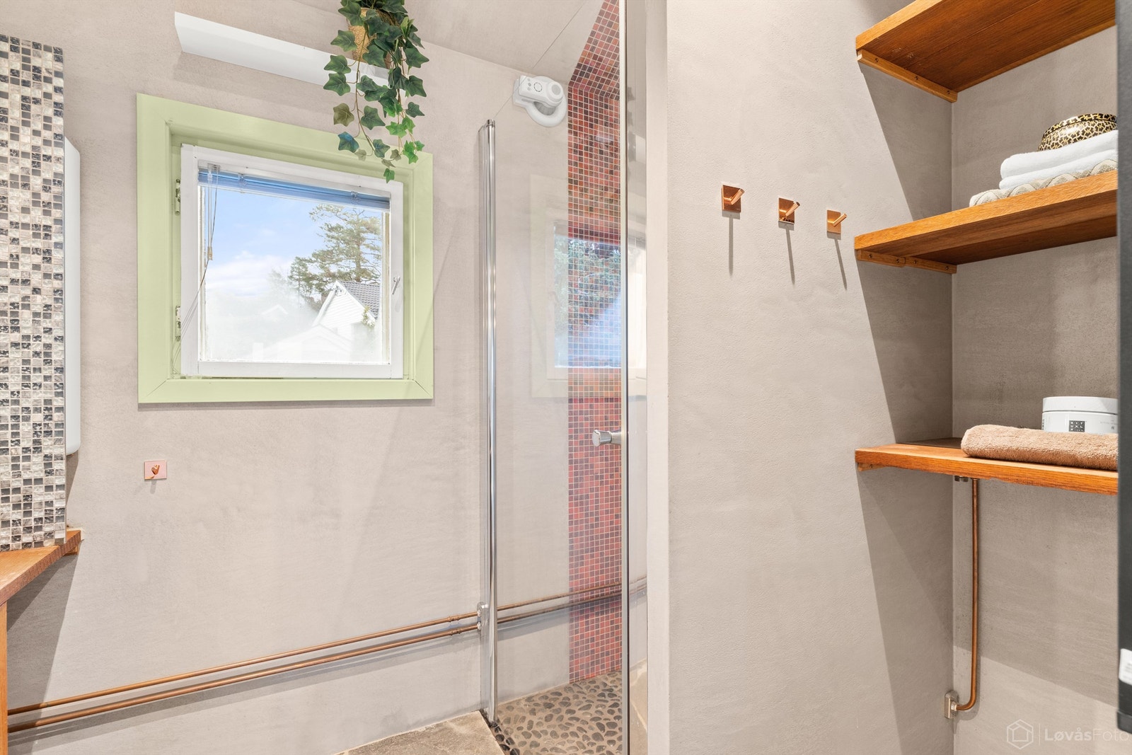 Dusjnisje med glassdør og automatisk, sensorstyrt avtrekksvifte. Synlige kobberrør for et gjennomført retropreg. Galleribilde