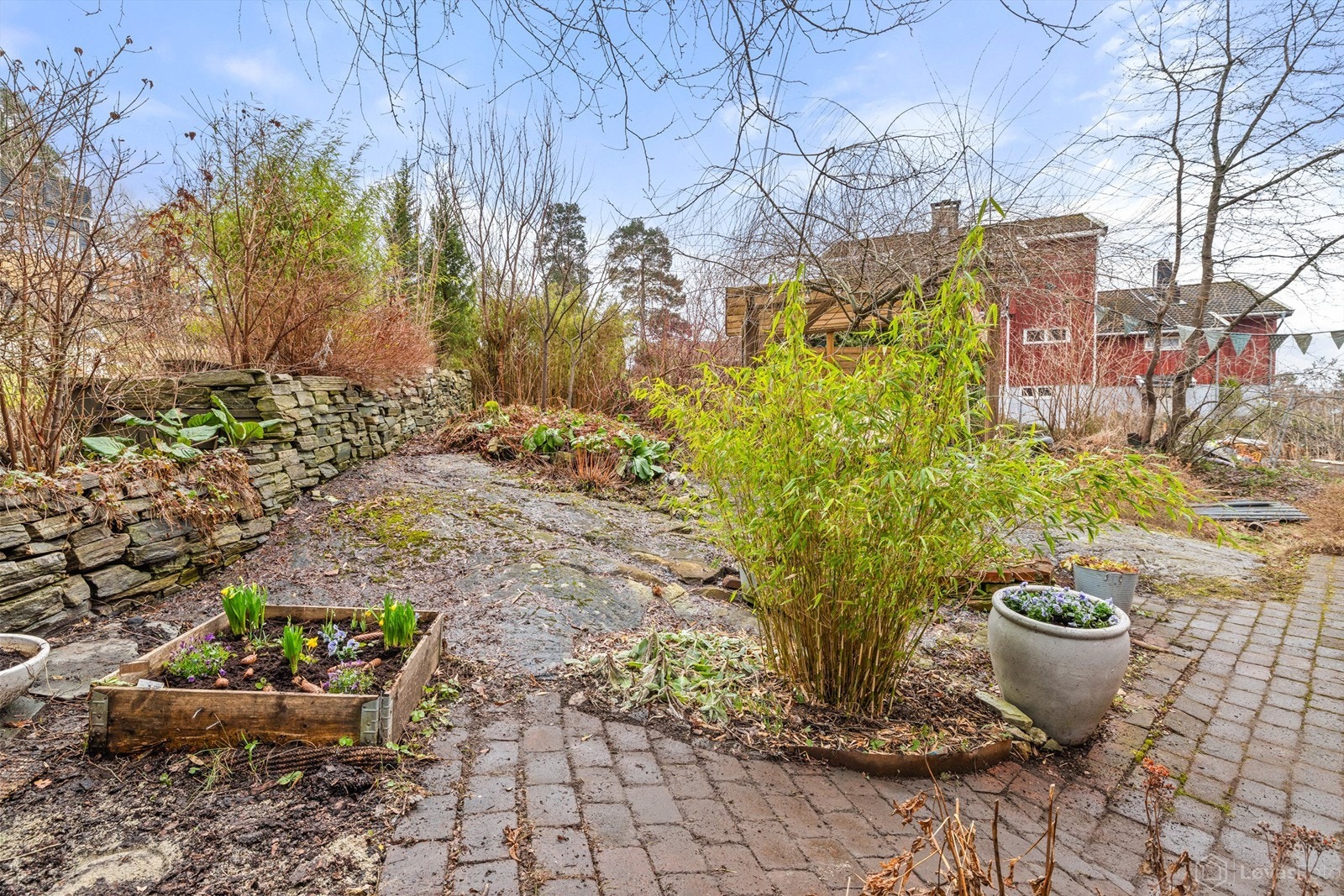 Hagen er pent opparbeidet og fremstår om sommeren som en privat, skjermet oase med frodige plantefelt, natursteinmurer og synlig, naturlig fjell. Galleribilde