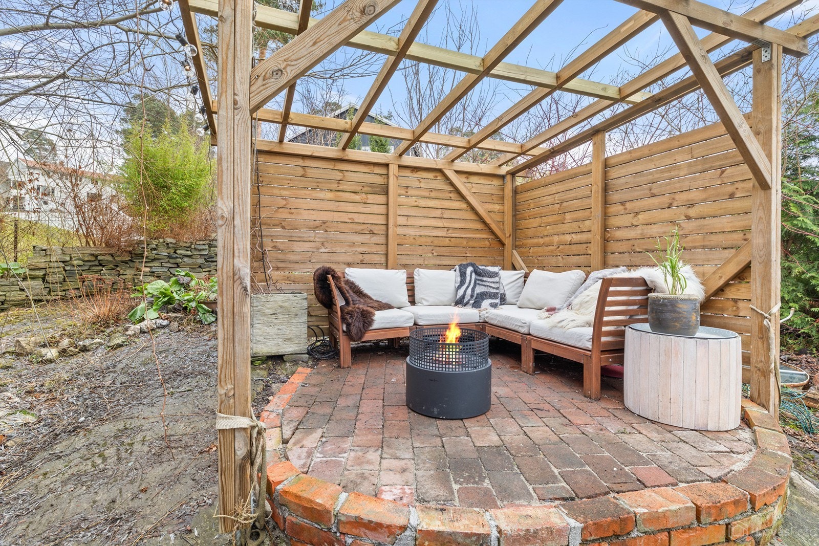 En lun og skjermet uteplass med pergola i hagen. Galleribilde