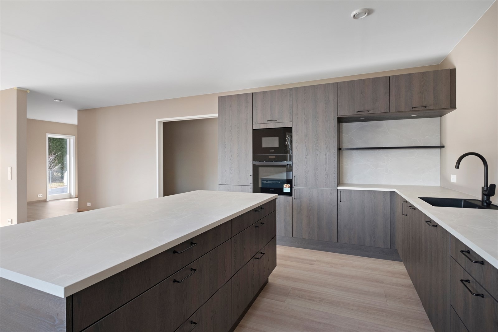 Hvitevarer som kjøl/fryseskap, oppvaskmaskin, induksjonstopp, mikro og stekeovn er integrert Galleribilde