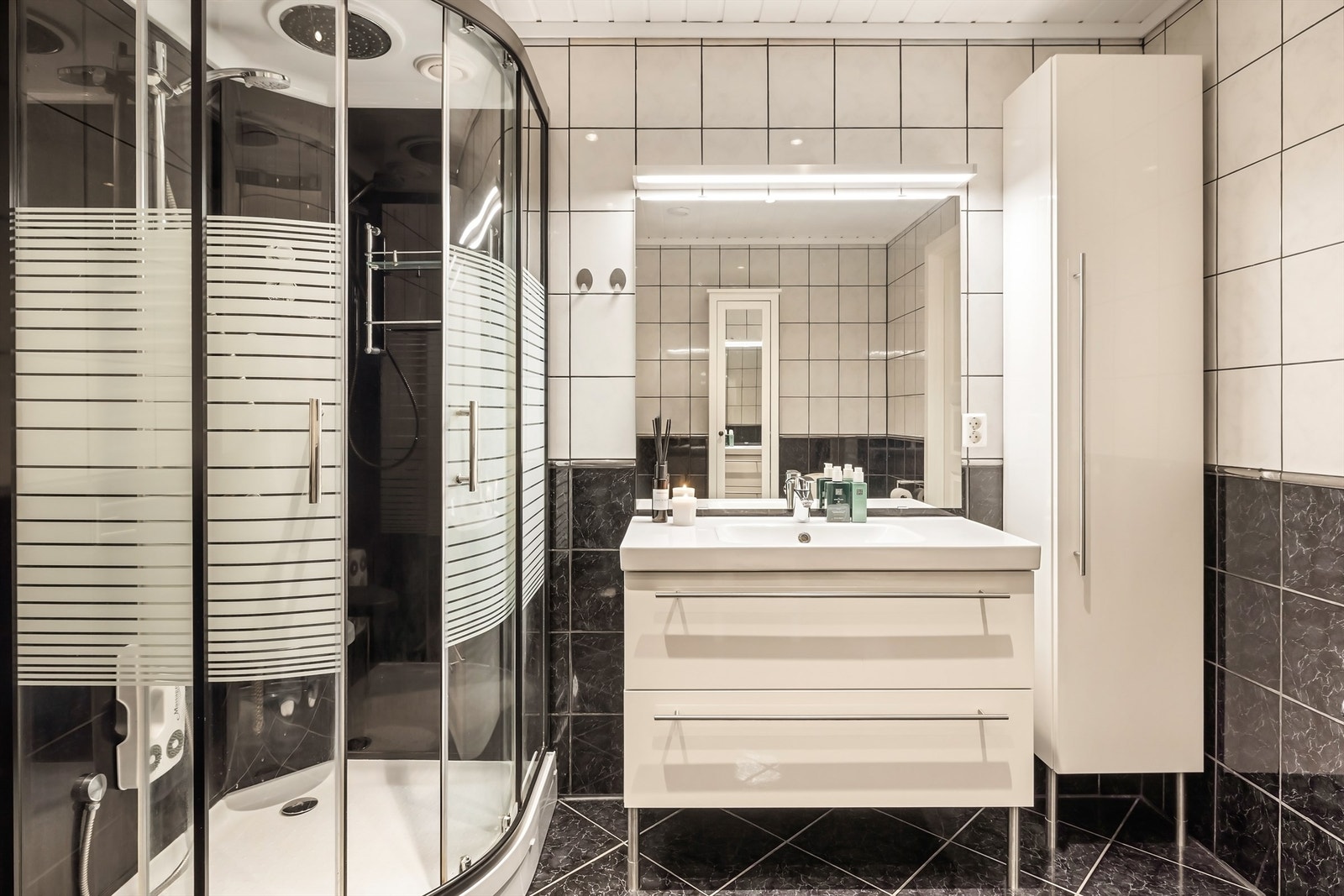 Rommet er utstyrt med dusjkabinett, servantinnredning med god oppbevaring og høyskap. Galleribilde