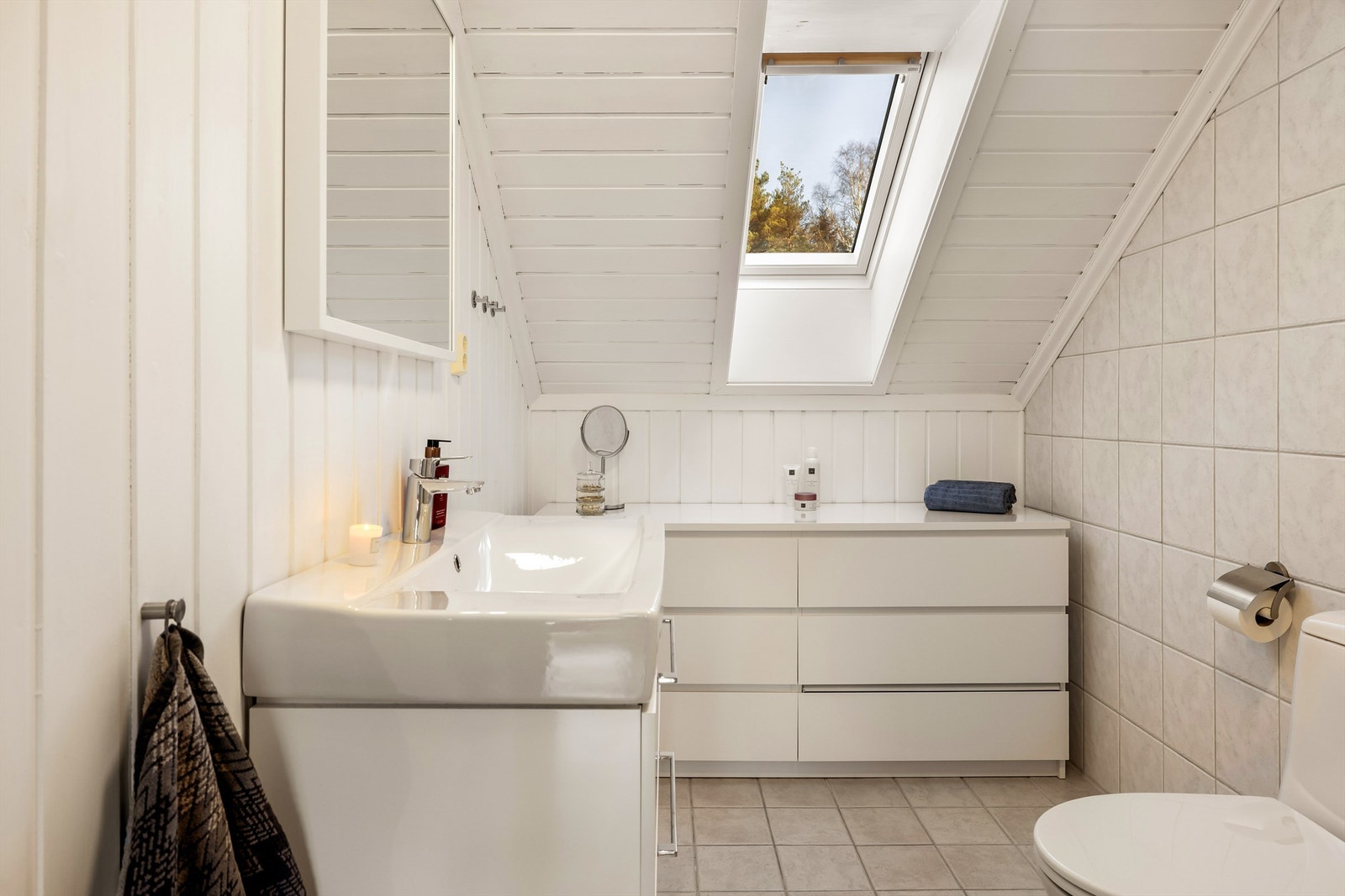 Badet i andre etasje har flislagt gulv med varmekabler og servant med god skuffeplass. Galleribilde