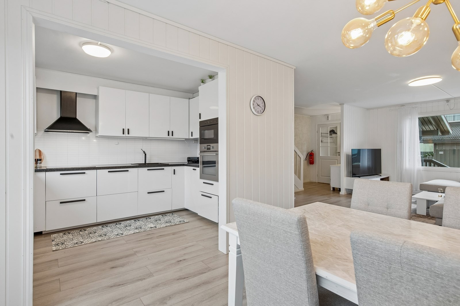 Kjøkkeninnredningen har glatte høyglansfolierte fronter, laminat benkeplate, kitchen wall over kjøkkenbenk, samt integrerte hvitevarer. Ventilatorhette med kullfilter. Galleribilde