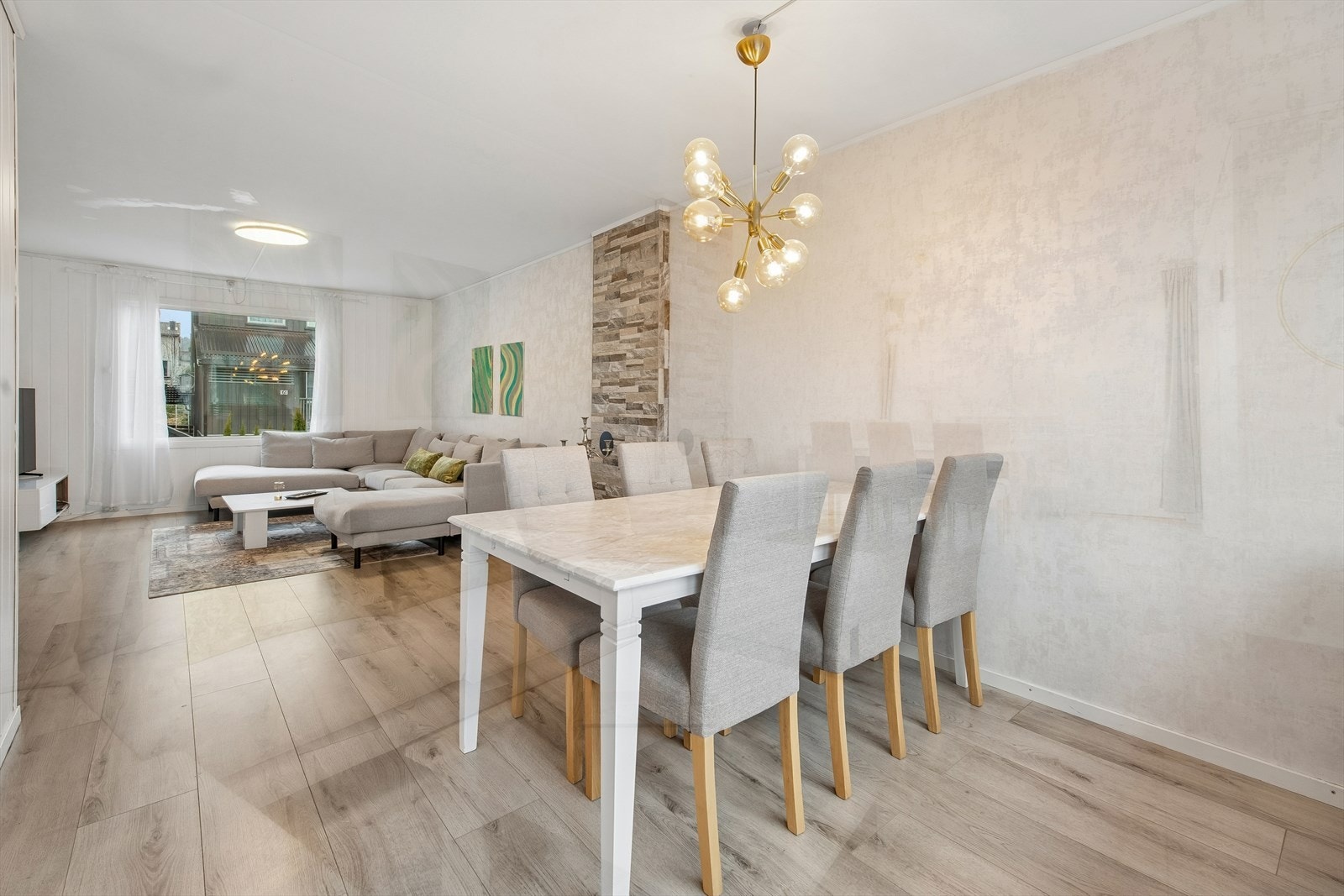 Stuen har laminatgulv, og tapet og malt panel på vegger Galleribilde