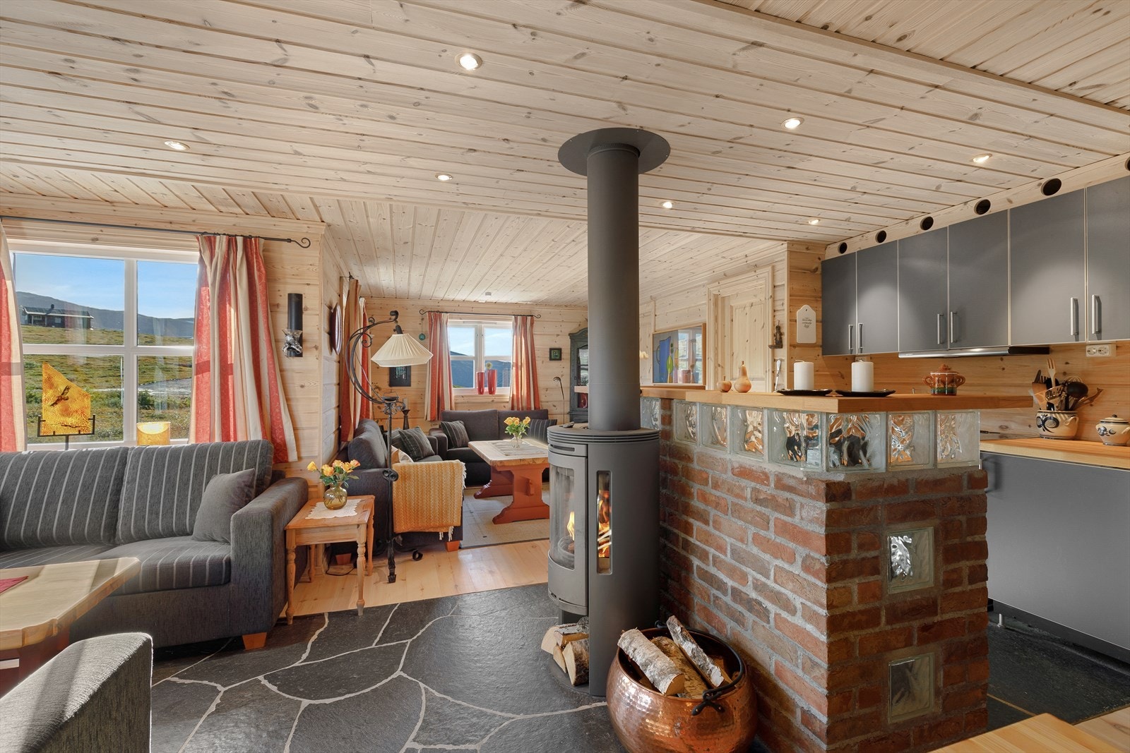 Åpen løysing mellom stove og kjøken, som samtidig er skjerma med halvveggar. Galleribilde