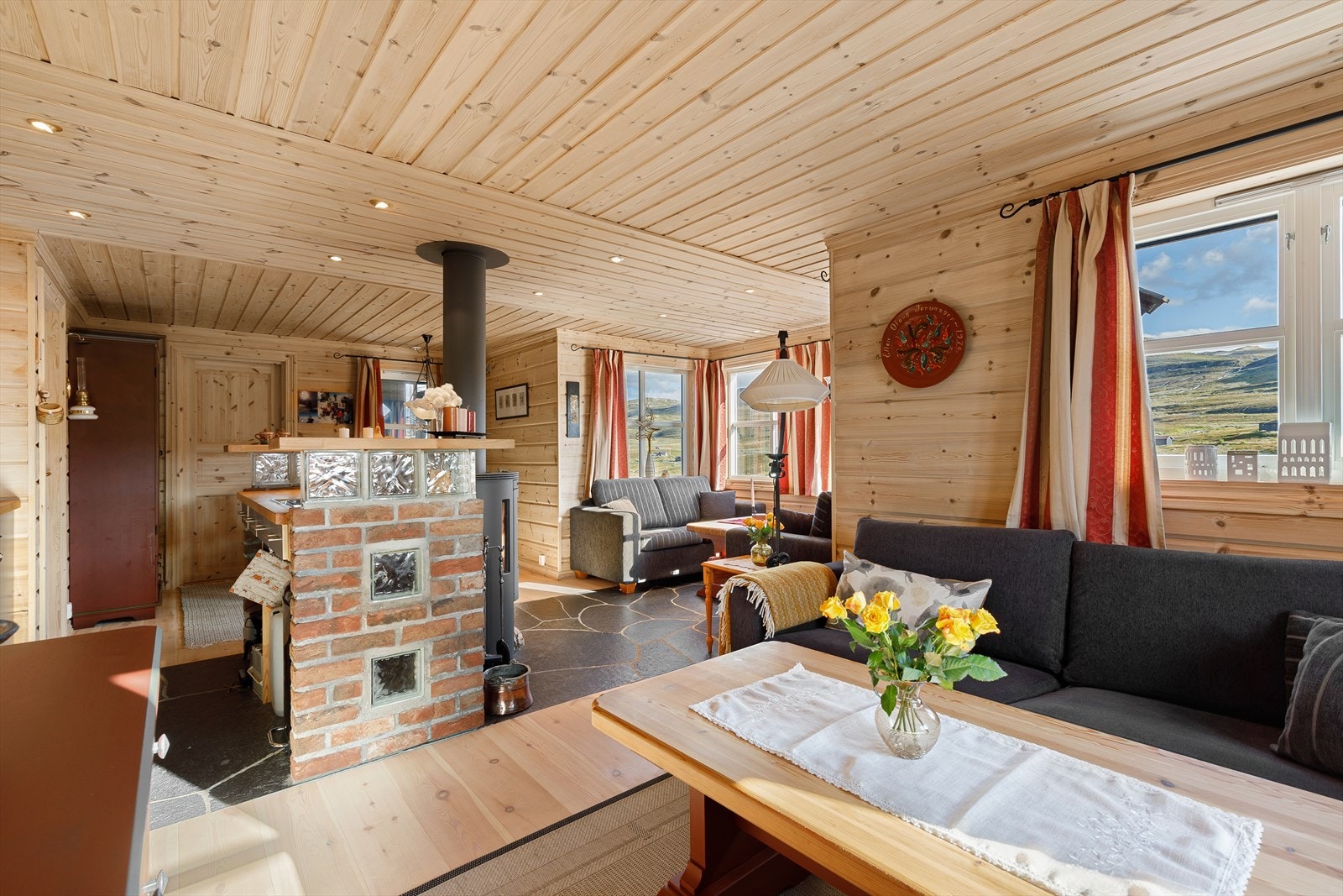 Vidare kjem du inn i resten av hytta. Her har du kjøken, spisebord og 2 sofasoner. Galleribilde