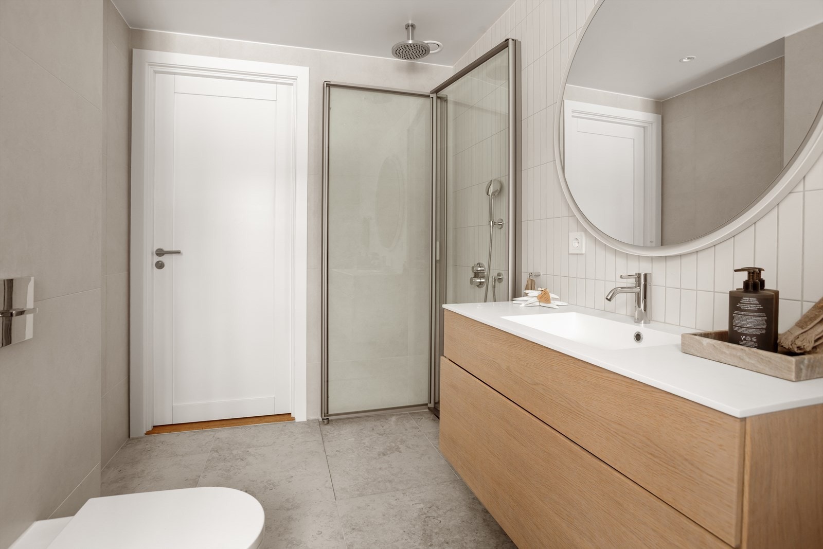 Pen innredning i lys eik, rundt speil og servant fra Dansani. Galleribilde