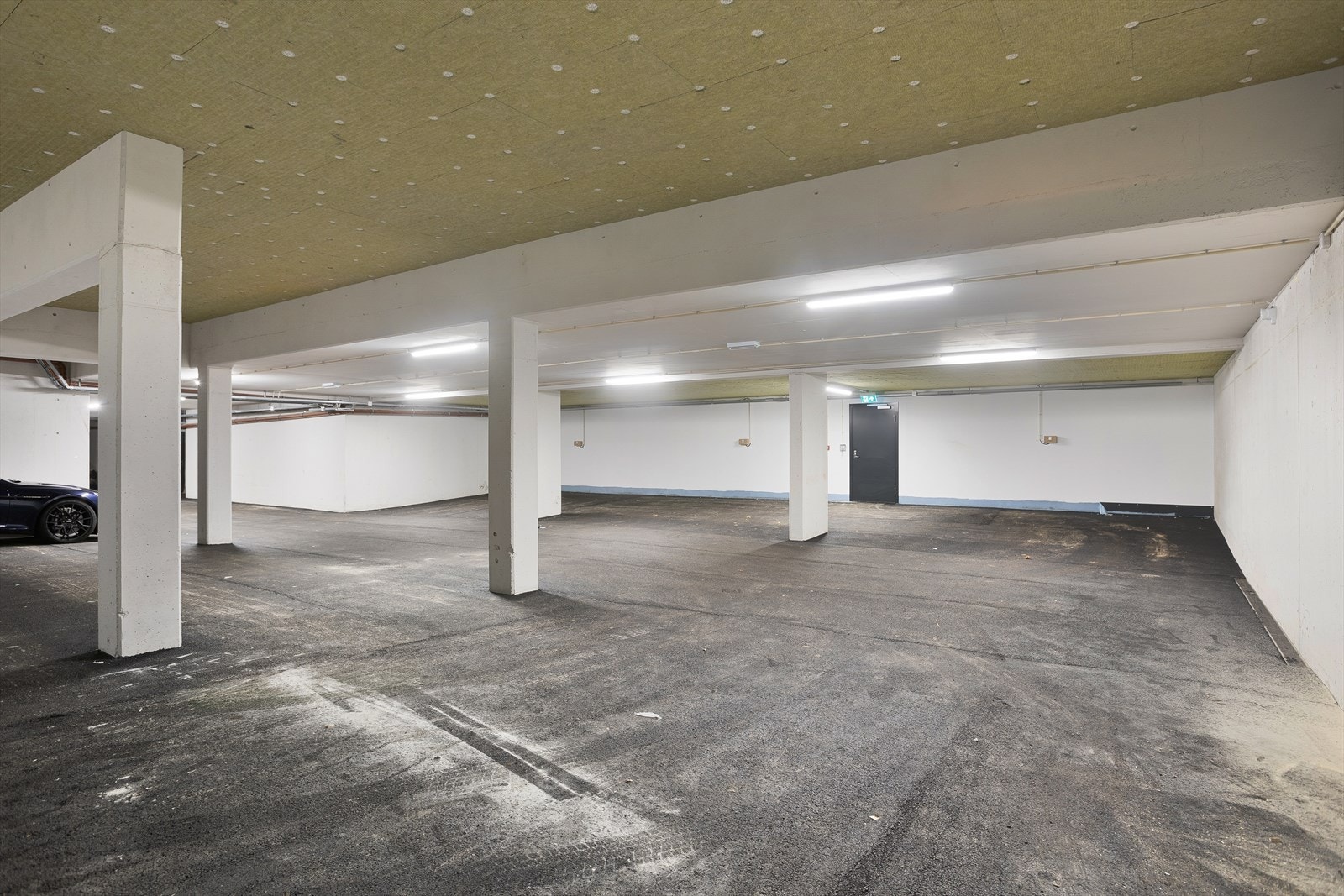 Stort garasjeanlegg i kjeller, hver seksjon har to parkeringsplasser. Galleribilde