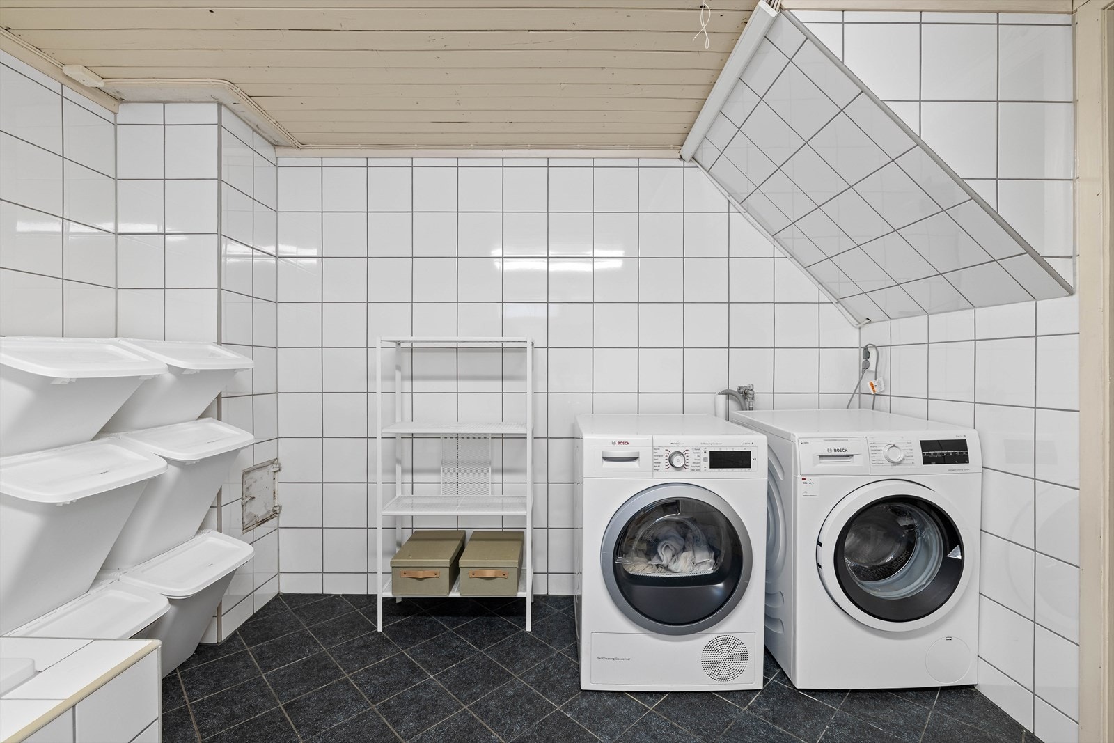 Badet er innredet med badekar, veggmontert toalett, innredning med nedfelt servant og opplegg for vaskemaskin. Det er mekanisk avtrekk Galleribilde
