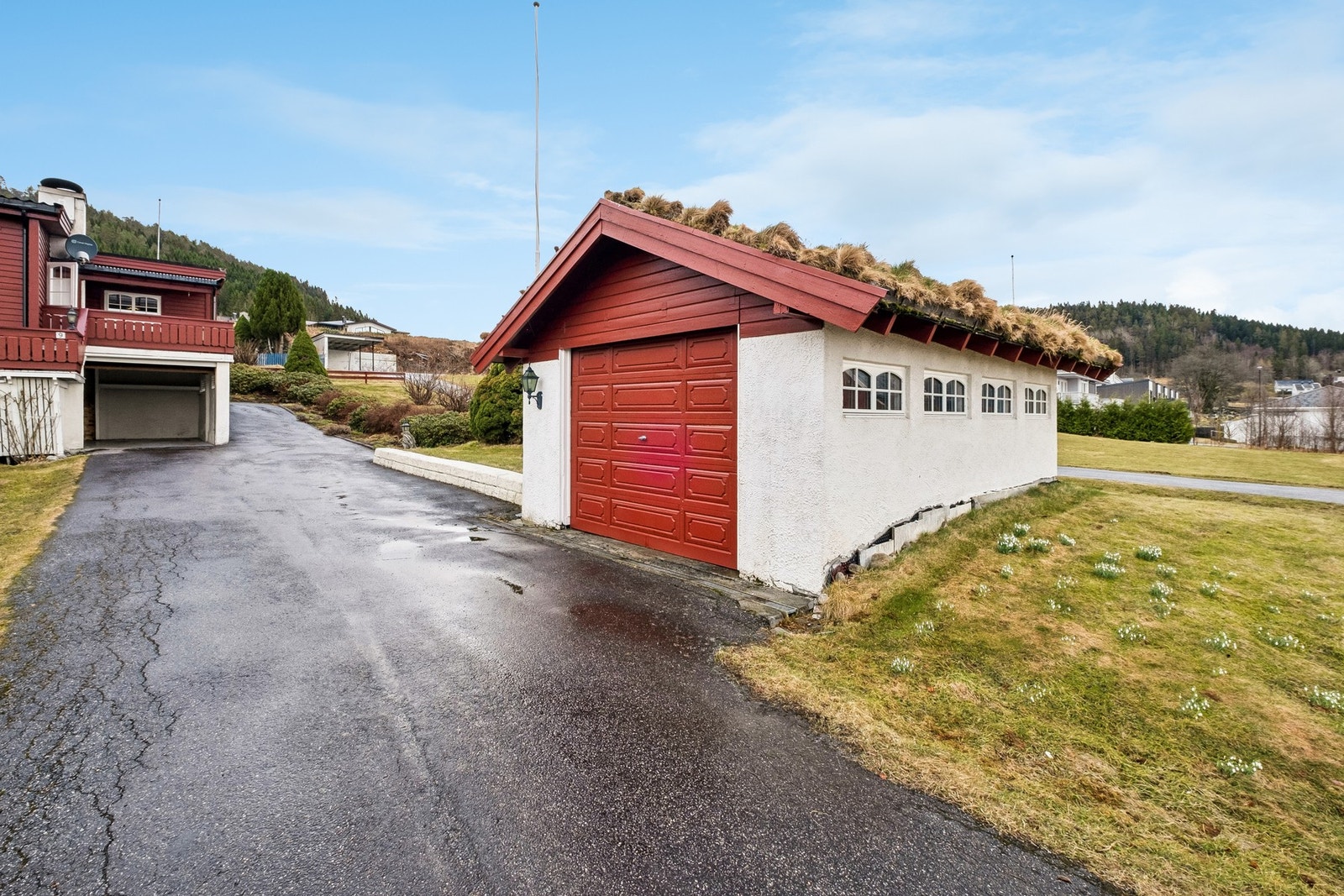 Frittstående garasje med port som har elektrisk portåpner sam garasje under terrasse i tilknytning til huset. Galleribilde