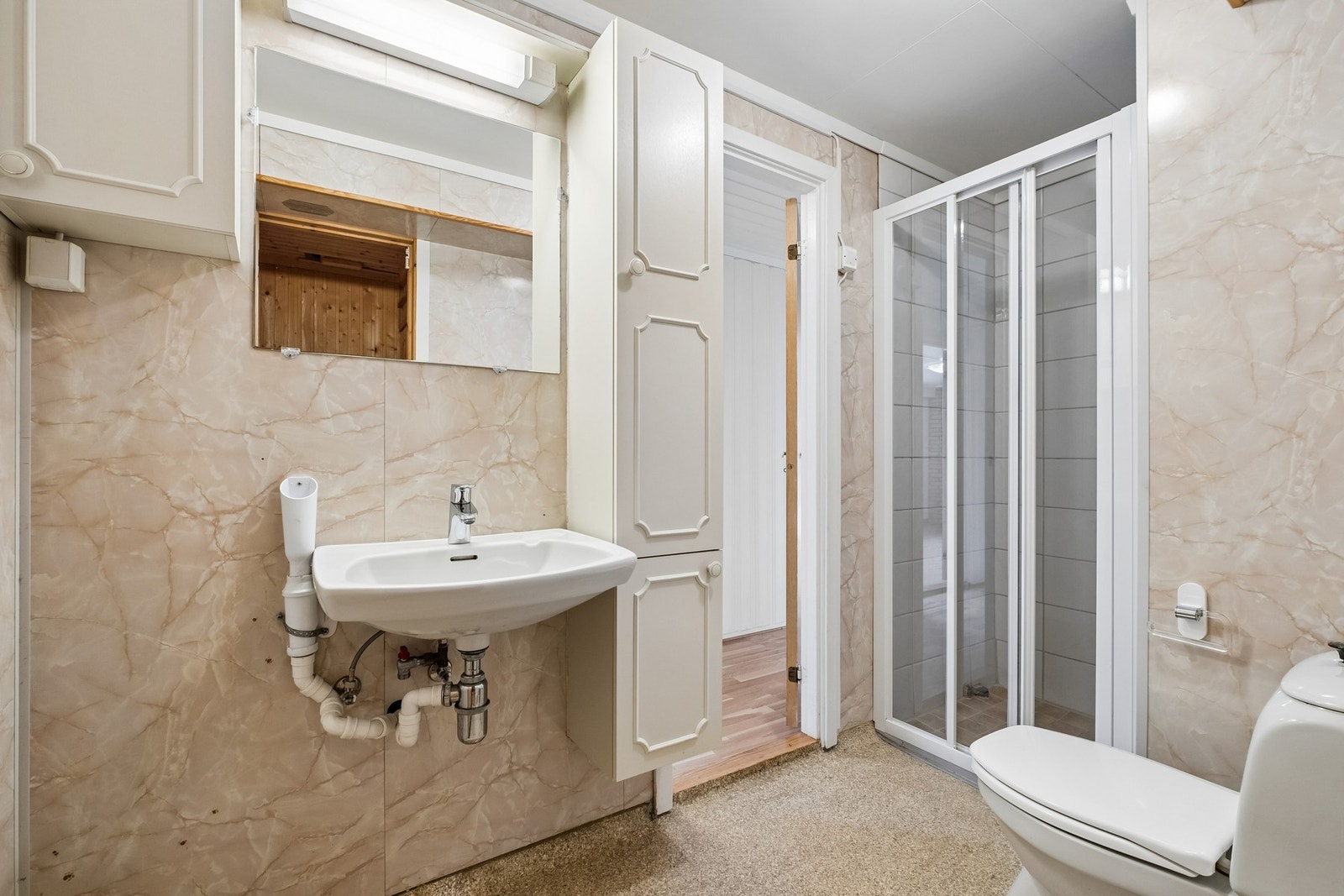 Badet har dusjkabinett, toalett og servant med speilskap. Opplegg for vaskemaskin. Galleribilde