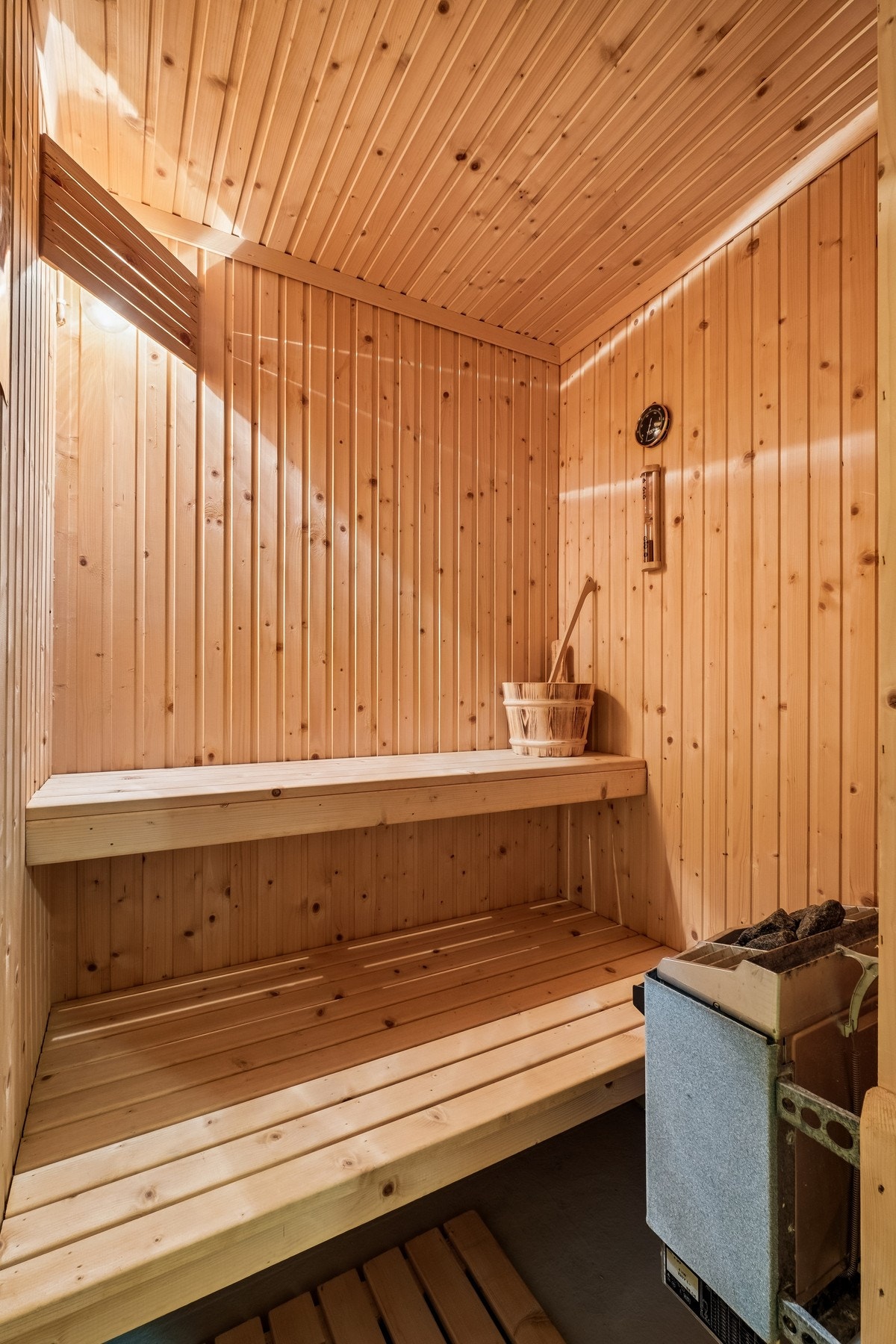 Fin badstue med trepanel på vegger og benker, samt badstuovn. Galleribilde