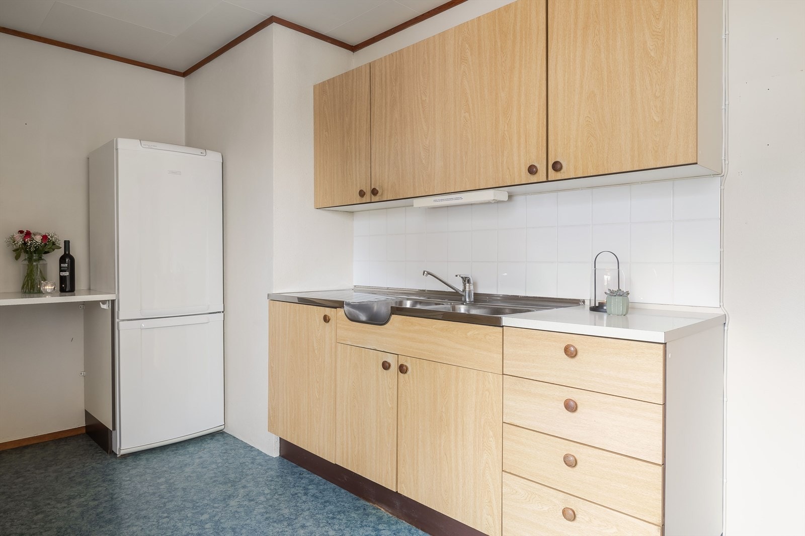 Benkebeslag med dobbel oppvaskkum. Det er plass for frittstående hvitevarer som kjøleskap og komfyr. Galleribilde